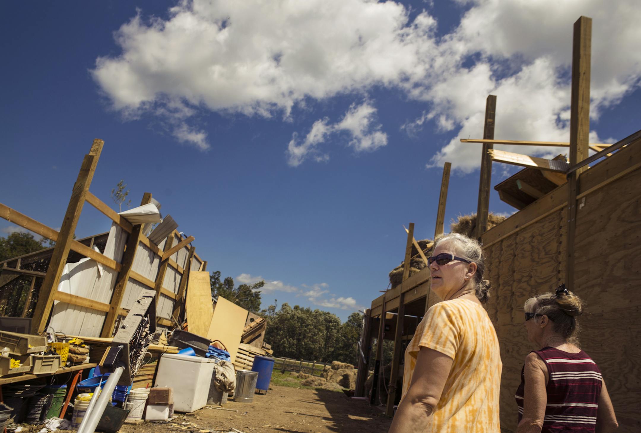 In the town of Hollywood, where an EF-1 tornado touched down, Patty Falk,left gave friendGloria Roelofs, right, a tour of the barn which was damaged. Her house sustained water damage and lost part of the roof.] Richard Tsong-Taatarii/rtsong-taatarii@startribune.com
