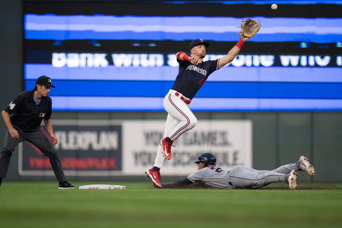 Cleveland’s Bo Naylor slid under Twins second baseman Edouard Julien with a stolen base in the fourth inning Tuesday night.