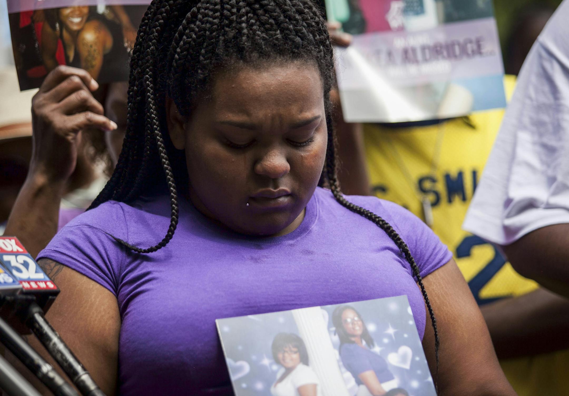 Raven Roberts held a picture of her aunt Nykea Aldridge at the vigil. Aldridge, 32, the cousin of NBA star Dwyane Wade, was pushing her baby in a stroller when she was fatally shot.