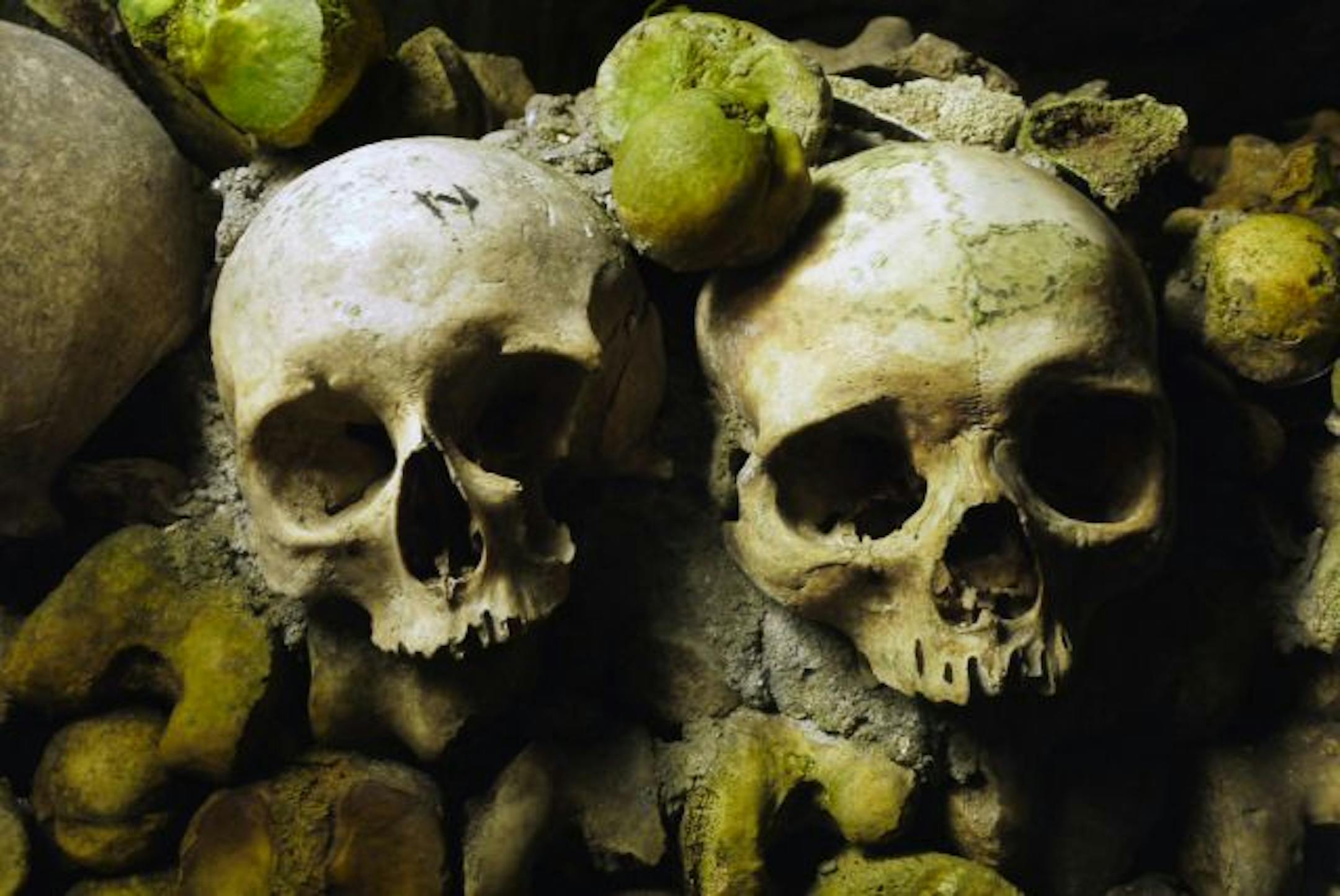 Two skulls are cemented into place, as if to greet the visitors, at the entrance to the ossuary in Paris' catacombs. The thick humidity in the underground cemetery has promoted a mossy growth on many of the bones.