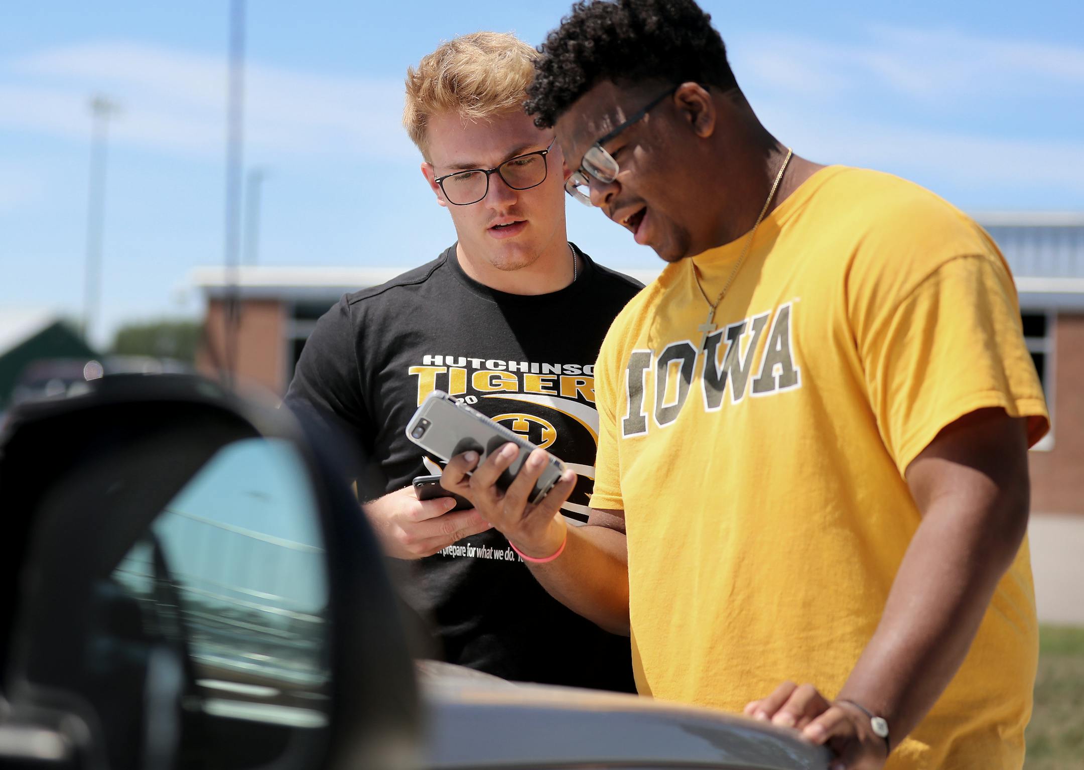 Hutchinson football players Ty Glaser, left, and Jordan Titus monitor their phones while waiting to hear how the MSHSL would vote on the upcoming football season, which they later voted to postpone until spring Tuesday, at Hutchinson High in Hutchinson. "I don't think it's set in yet," Titus said. "It doesn't feel real."