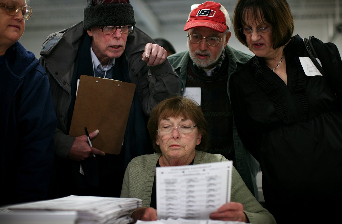 All eyes were focused on a ballot held up by Minneapolis Election Judge Marge Dolan on Wednesday. She was surrounded, from left, by fellow Judge Julia Nelson, Franken monitor Zev Aelony and Coleman monitors Alan Shilepsky and Nancy Bernard. The recount in the U.S. Senate race was held in a warehouse in northeast Minneapolis.