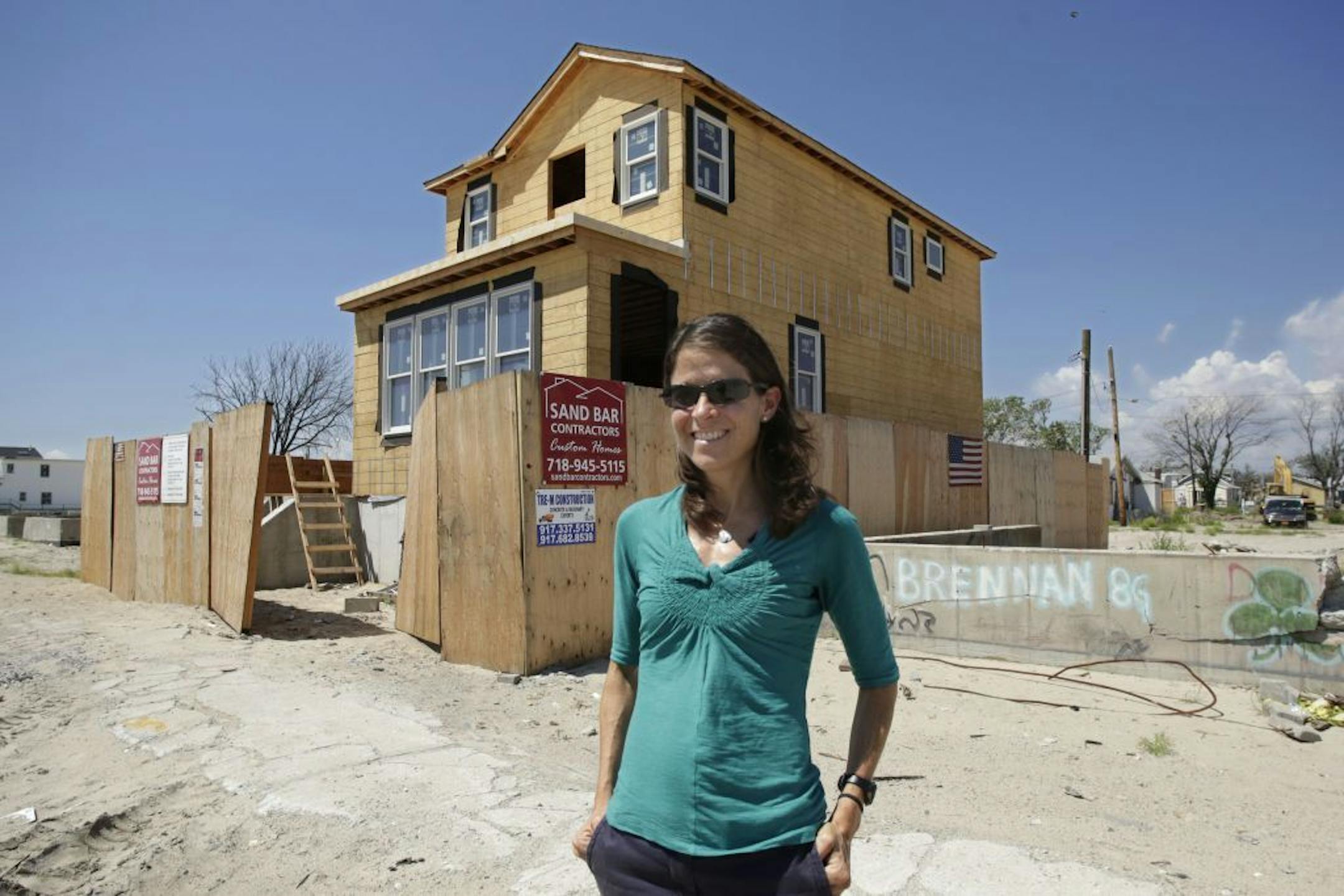 In this Aug. 2, 2013 photo, Sue Flynn stands in front of her home under construction in the Breezy Point section of the Queens borough of New York.