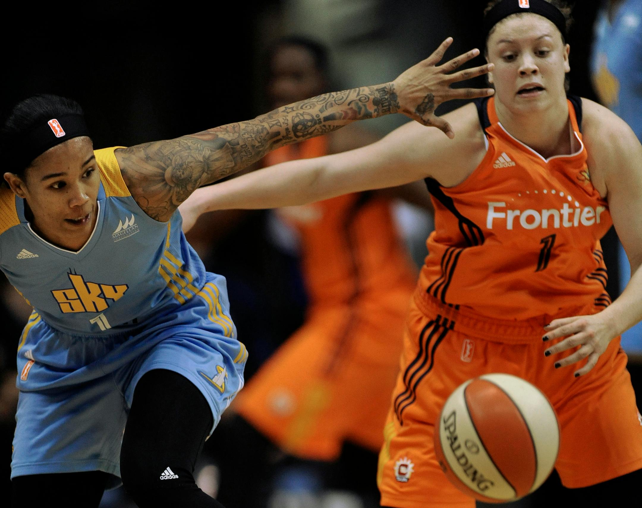 Chicago's Tamera Young, left, battled Connecticut's Rachel Banham for a loose ball during Saturday's WNBA opener in Chicago. Banham, an All-America player for the Gophers, scored 13 points in her pro debut, but the Sky beat the Sun 93-70.