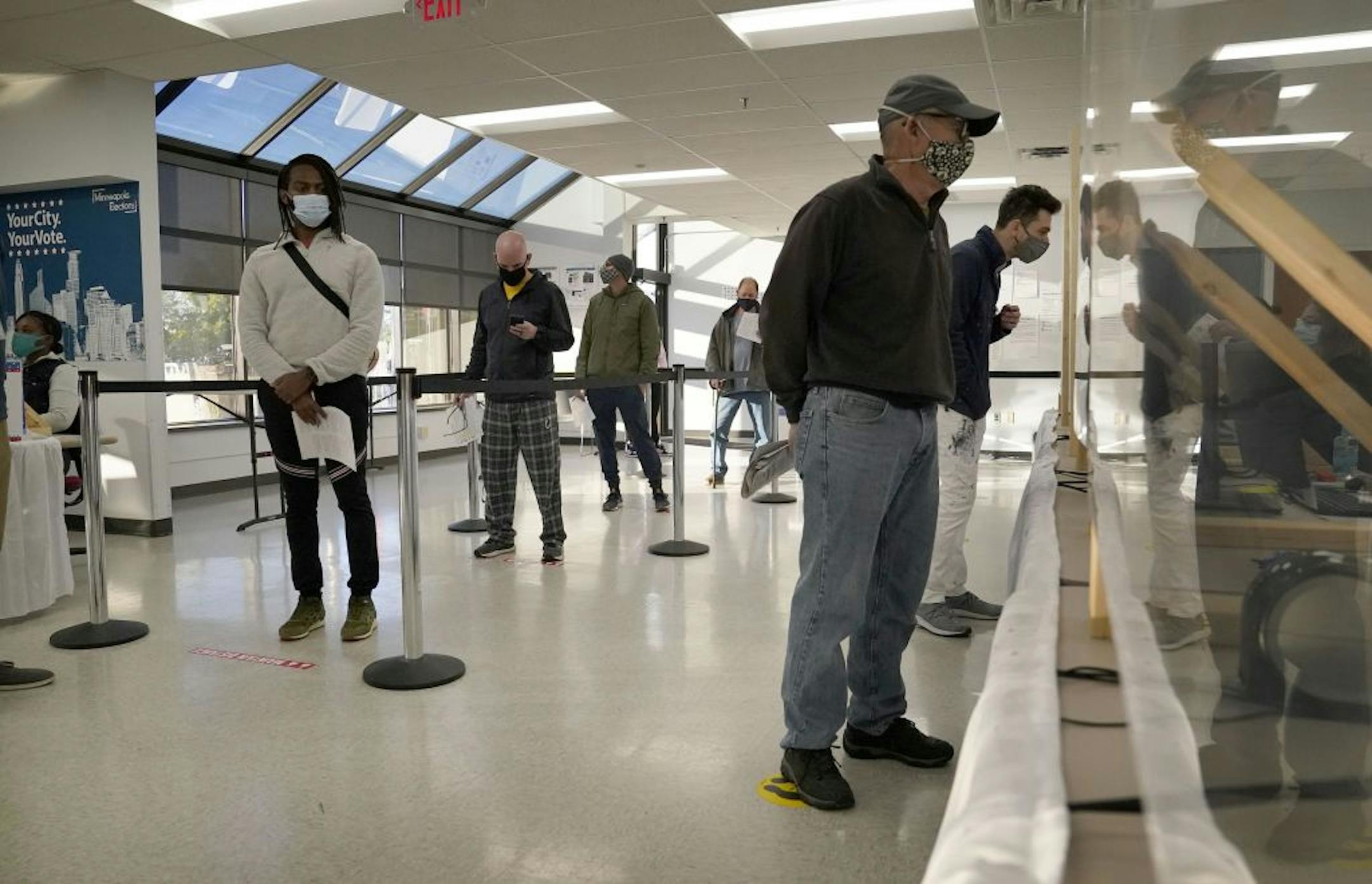 Voters wore masks, social distanced and were separated from poll workers with protective barriers during early voting at Minneapolis Elections and Voter Services Friday in Minneapolis.