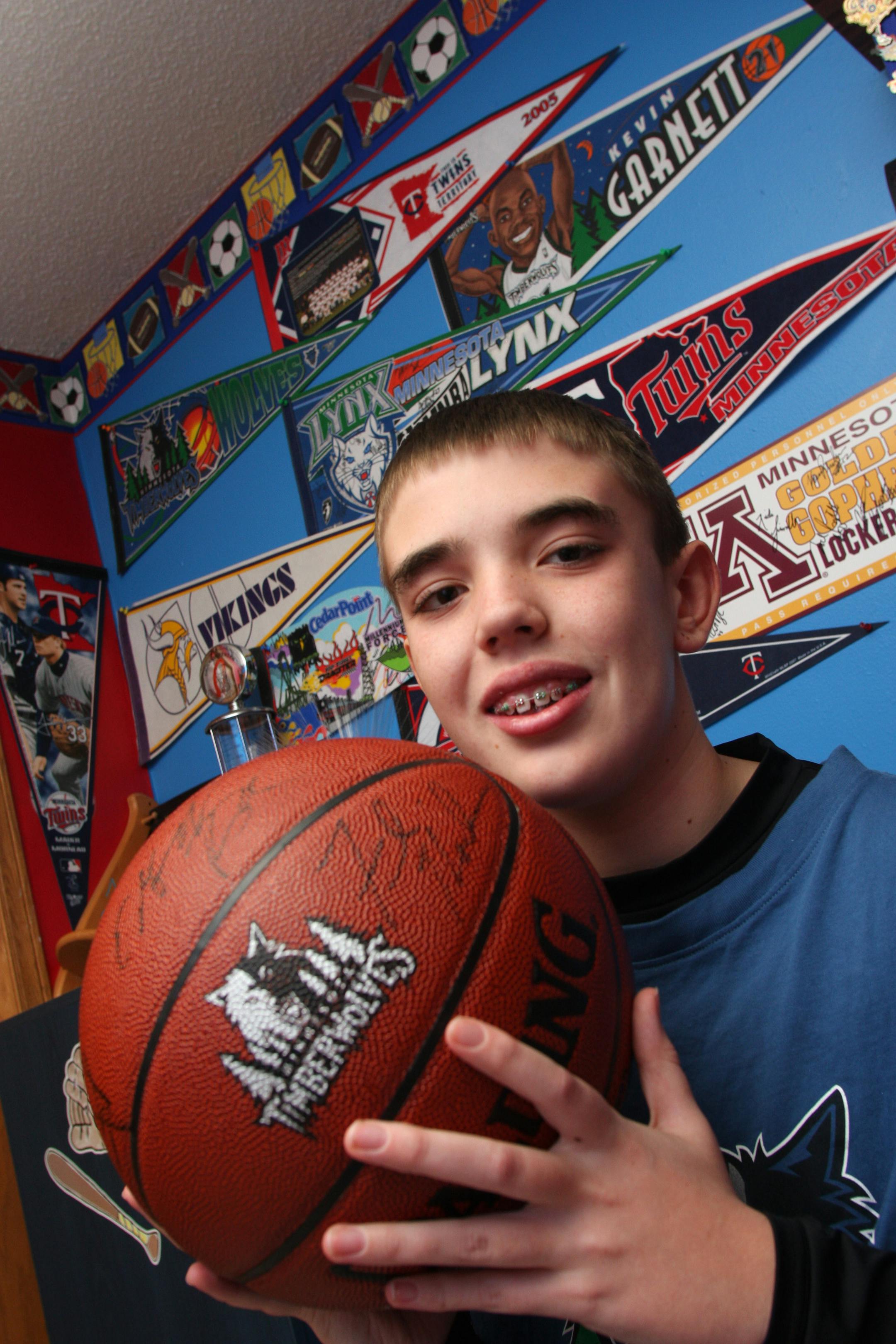 (left to right) Matthew Gamber, a 6th grader in Brooklyn Park who has undergone hundreds of surgeries to his heart, lymph nodes and gums has always been a sports fan. He was photographed in his bedroom with a basketball signed by former Timberwolves Kevin Garnett and other teammates from last years squad.