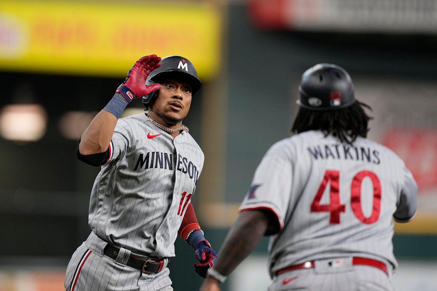 Minnesota Twins' Jorge Polanco greets third base coach Tommy Watkins (40) after a three-run home run during the seventh inning in Game 1 of an American League Division Series baseball game against the Houston Astros, Saturday, Oct. 7, 2023, in Houston. (AP Photo/Tony Gutierrez)