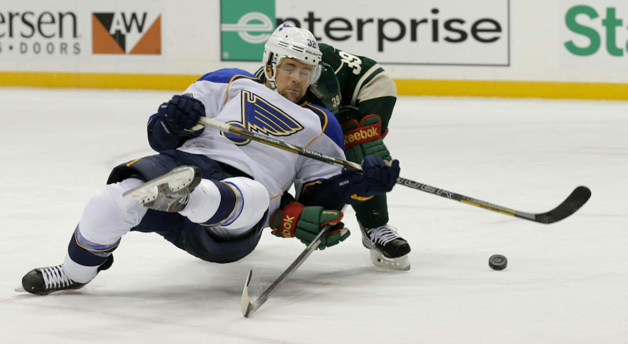 St. Louis left wing Chris Porter, left, fell as he tangled with Wild defenseman Nate Prosser as they chased the puck during Tuesday's game.