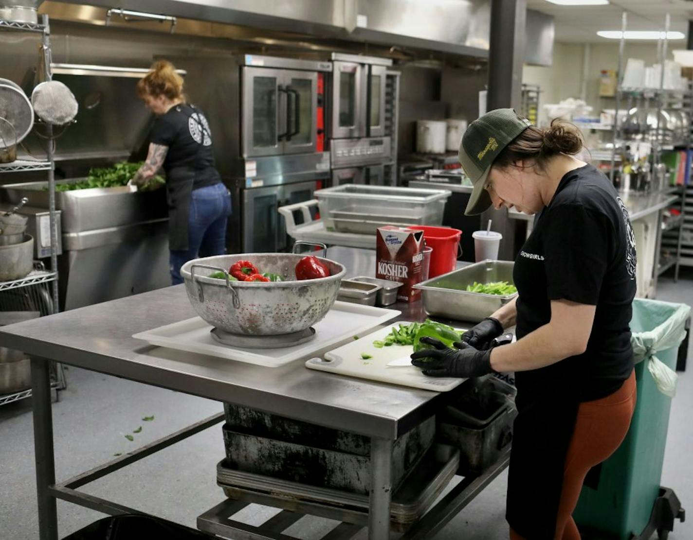 Kate Kiernoziak, Chowgirls Killer Catering sous chef, right, and Arianna Baker-Kern, Chowgirls Killer Catering chef de cuisine, prepare ingredients for cooked dishes that will be distributed by Loaves & Fishes to people in need Wednesday, March 18, 2020, in Minneapolis, MN. Much of the food came from Second Harvest Heartland and much of that was collected from local restaurants that are now closed.