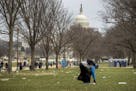 The Capitol building is visible as a man who declined to give his name picks up garbage during a partial government shutdown on the National Mall in W