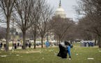 The Capitol building is visible as a man who declined to give his name picks up garbage during a partial government shutdown on the National Mall in W