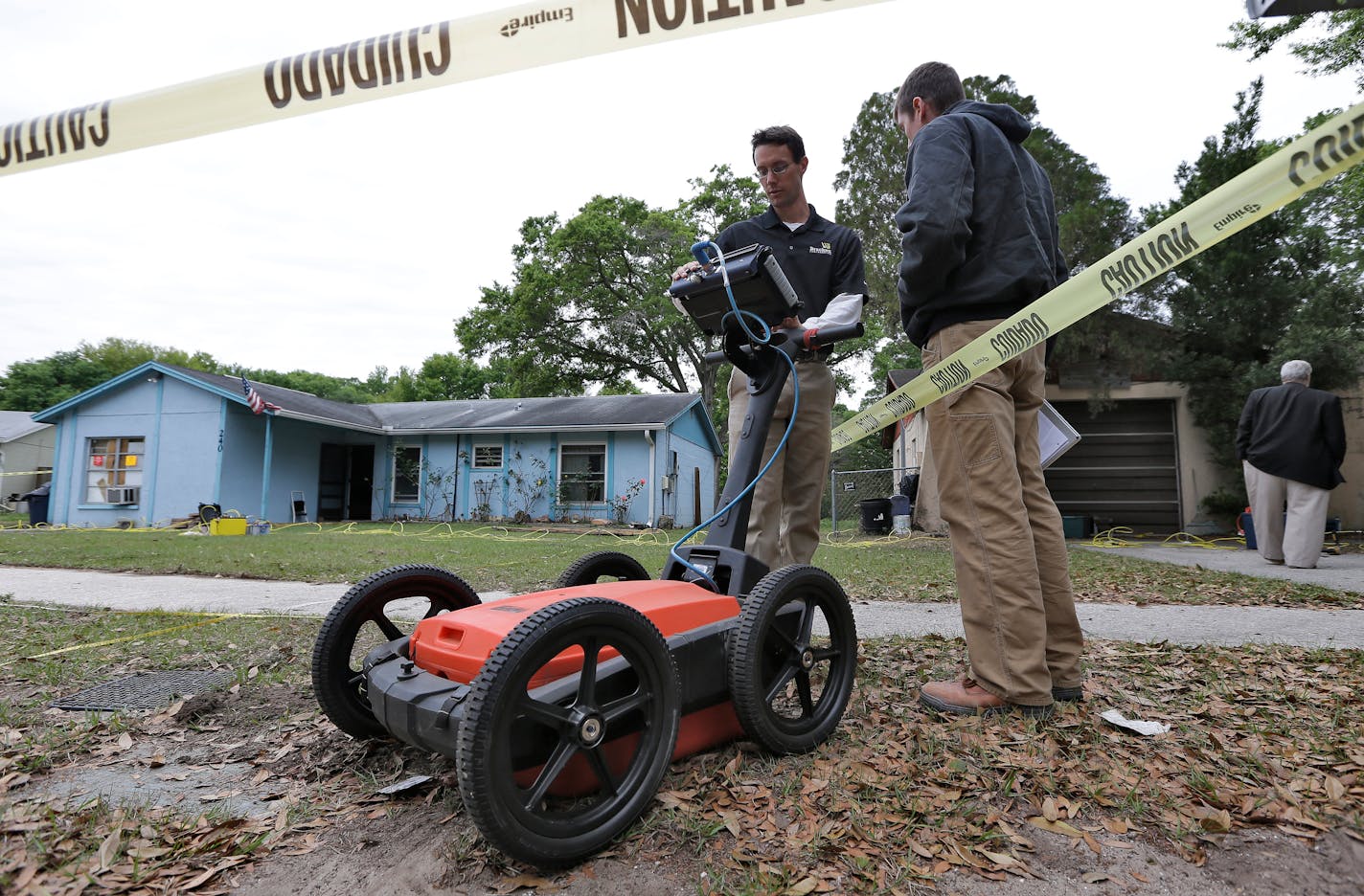Engineers work in front of a home where sinkhole opened up underneath a bedroom and swallowed a man Friday, March 1, 2013, in Seffner, Fla. Jeff Bush screamed for help and disappeared as a large sinkhole opened under the bedroom of his house, his brother said Friday. Jeremy Bush told rescue crews he heard a loud crash near midnight Thursday, then heard his brother screaming. There's been no contact with Jeremy Bush s since then, and neighbors on both sides of the home have been evacuated. (AP Ph