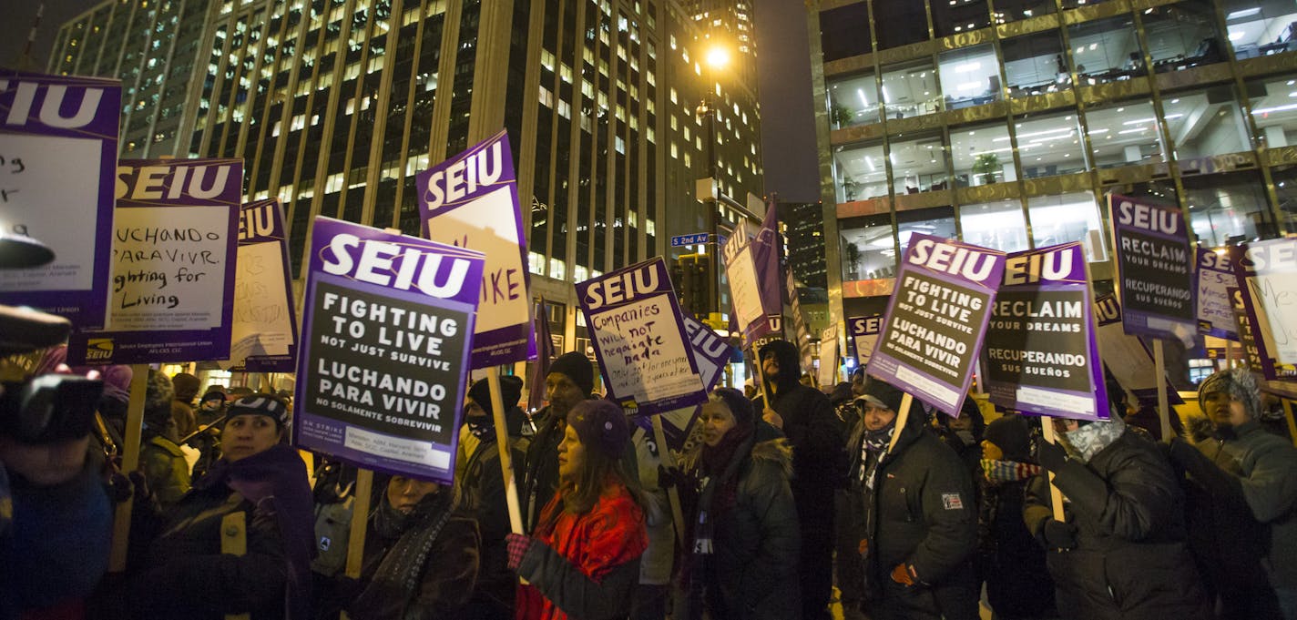 People walked holding signs in a circle during a one-day protest for local janitors a outside the U.S. Bank building on Wednesday, February 17, 2016, in Minneapolis, Minn. ] RENEE JONES SCHNEIDER &#x2022; reneejones@startribune.com