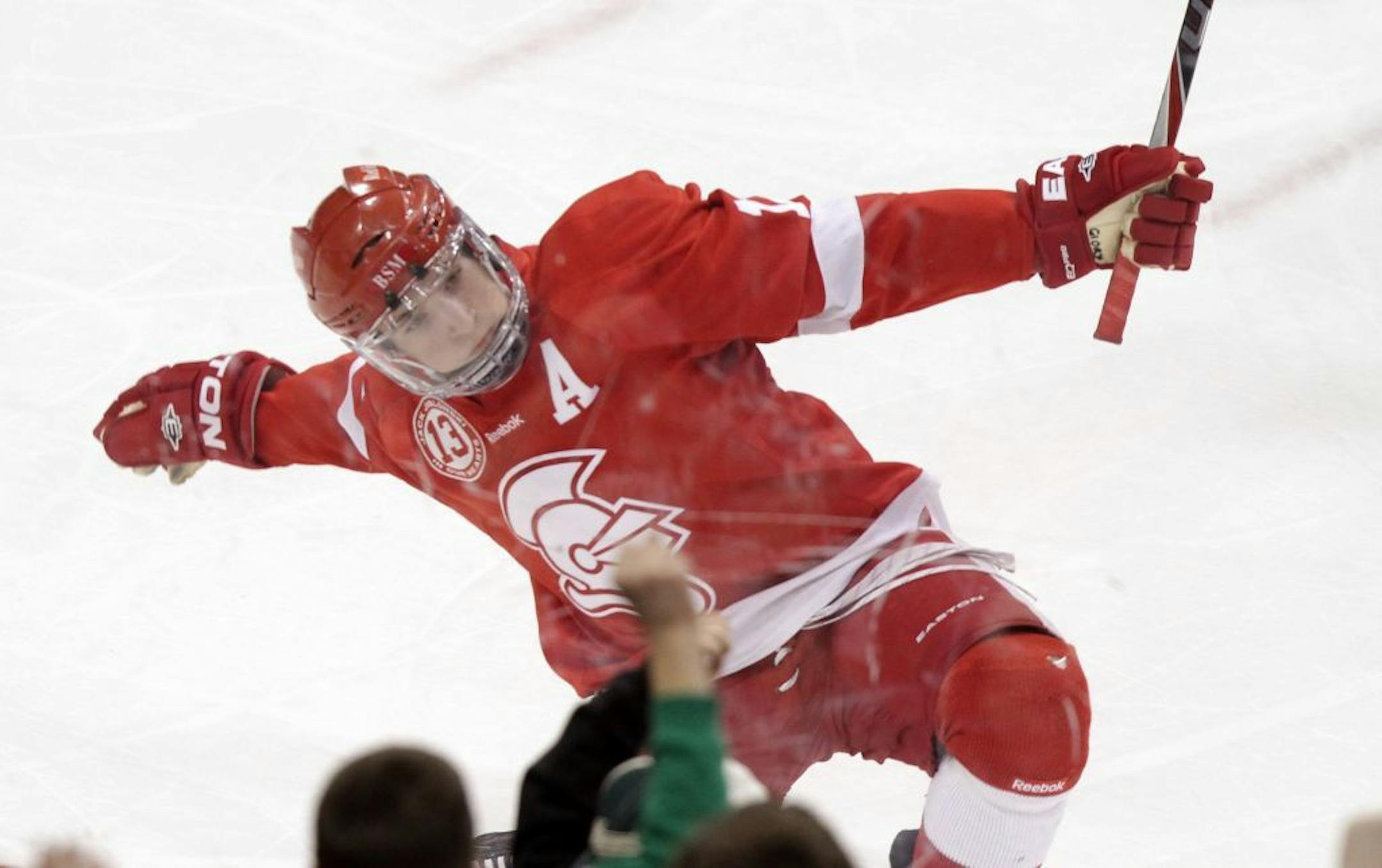 Benilde-St. Margaret's forward Grant Besse, sporting his new gloves, celebrates a first-period goal against Hill-Murray on Saturday.