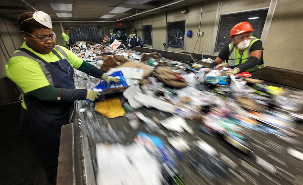 Staff at Eureka Recycling remove non-recyclable materials from the pre-sort line at the company's northeast Minneapolis facility.