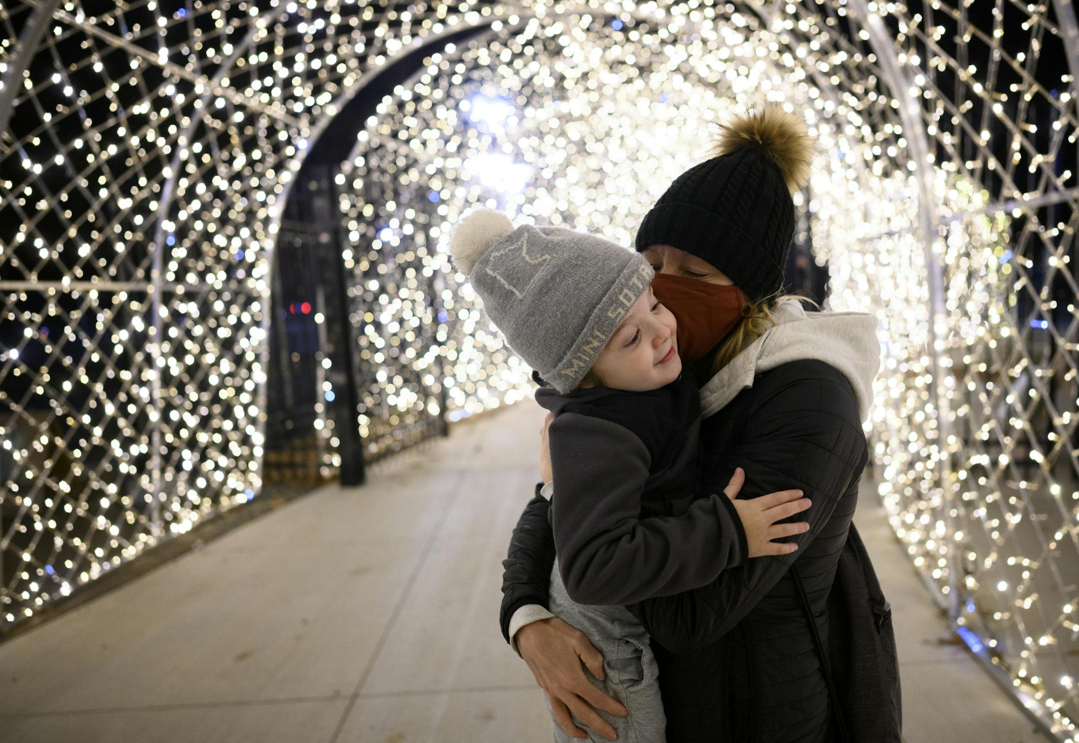 Sarah Kasner kissed her 5-year old son, Dunky, under the lights near the GLOW Holiday Festival's outdoor food court Wednesday. ] AARON LAVINSKY • aaron.lavinsky@startribune.com Drive-through is the name of the entertainment game this fall and winter. The GLOW Holiday Light event at the state fairgrounds is just one of the new breed of holiday light shows coming onboard in 2020. We photograph the GLOW Holiday Festival on Wednesday, Nov. 18, 2020 in Falcon Heights, Minn.