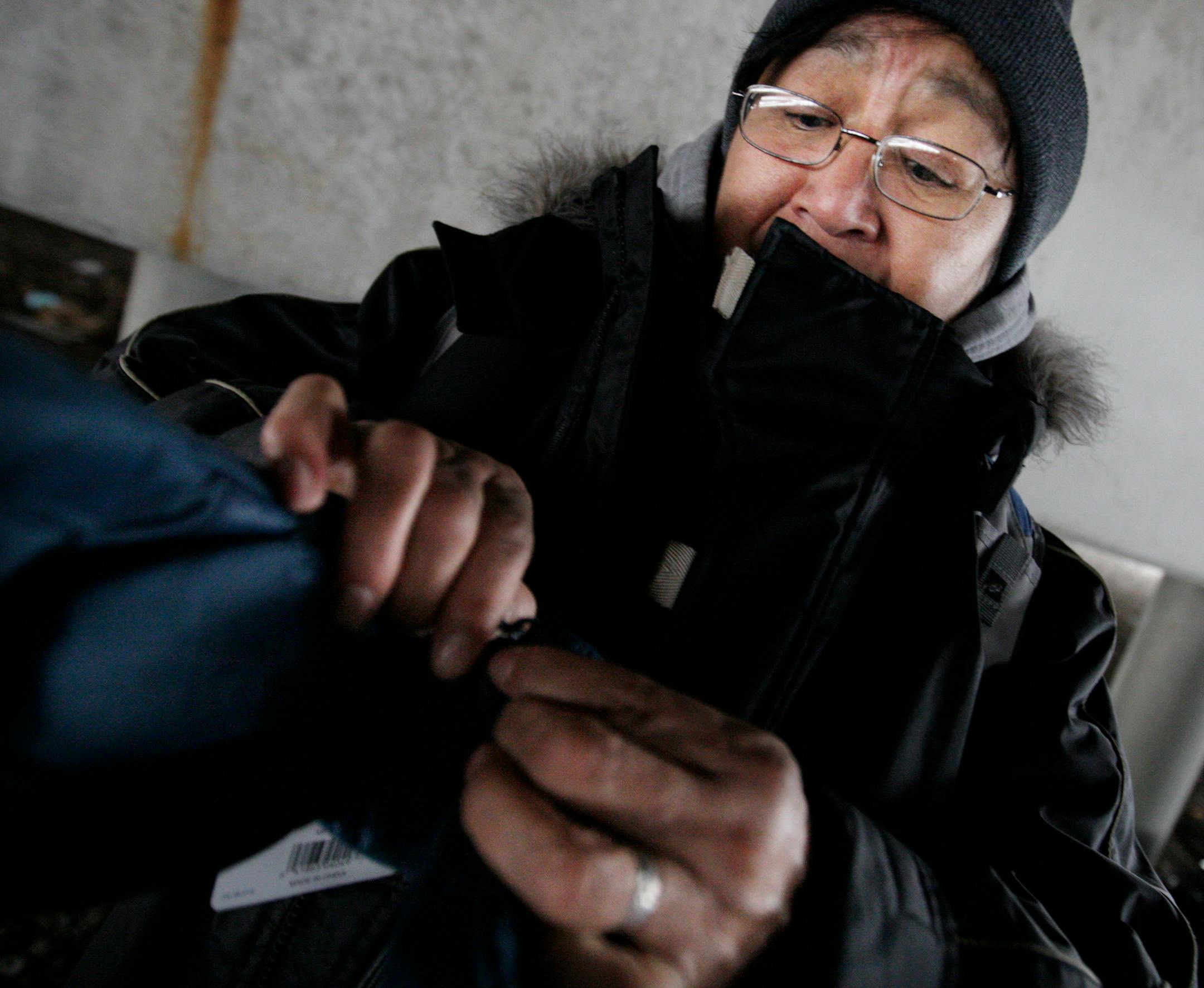 Charlene Goggleeye unwrapped her new winter gloves brought to her by outreach workers from St. Stephen's Human Services.