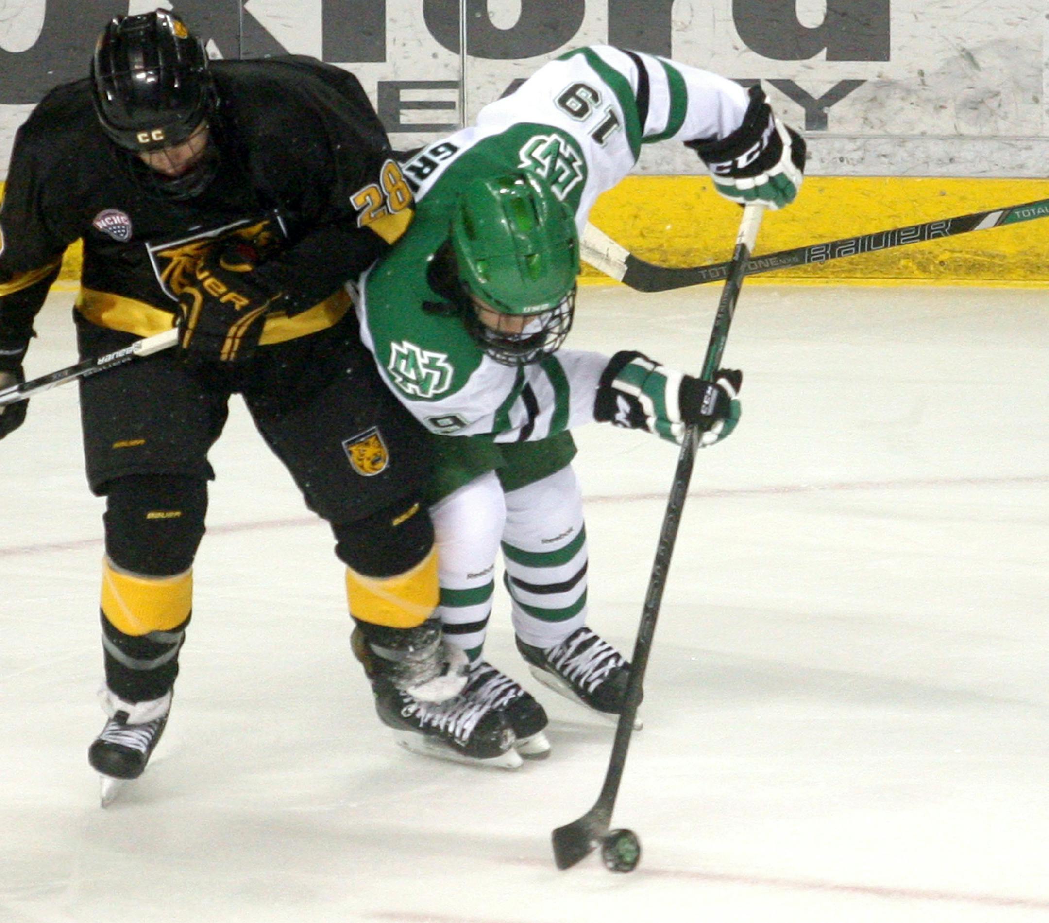 Colorado College's Alex Roos, left, battles North Dakota's Rocco Grimaldi (19) as UND's Paul LaDue (6) looks on in the first period of a hockey game on Friday, Jan. 10, 2014, in Grand Forks, N.D. (AP Photo/Bruce Crummy) ORG XMIT: NNDBC904