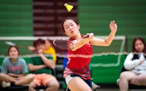 St. Paul Highland Park’s Phlower Vang returns the birdie to Kimberly Tobar of St. Paul Harding during their badminton high school state championship