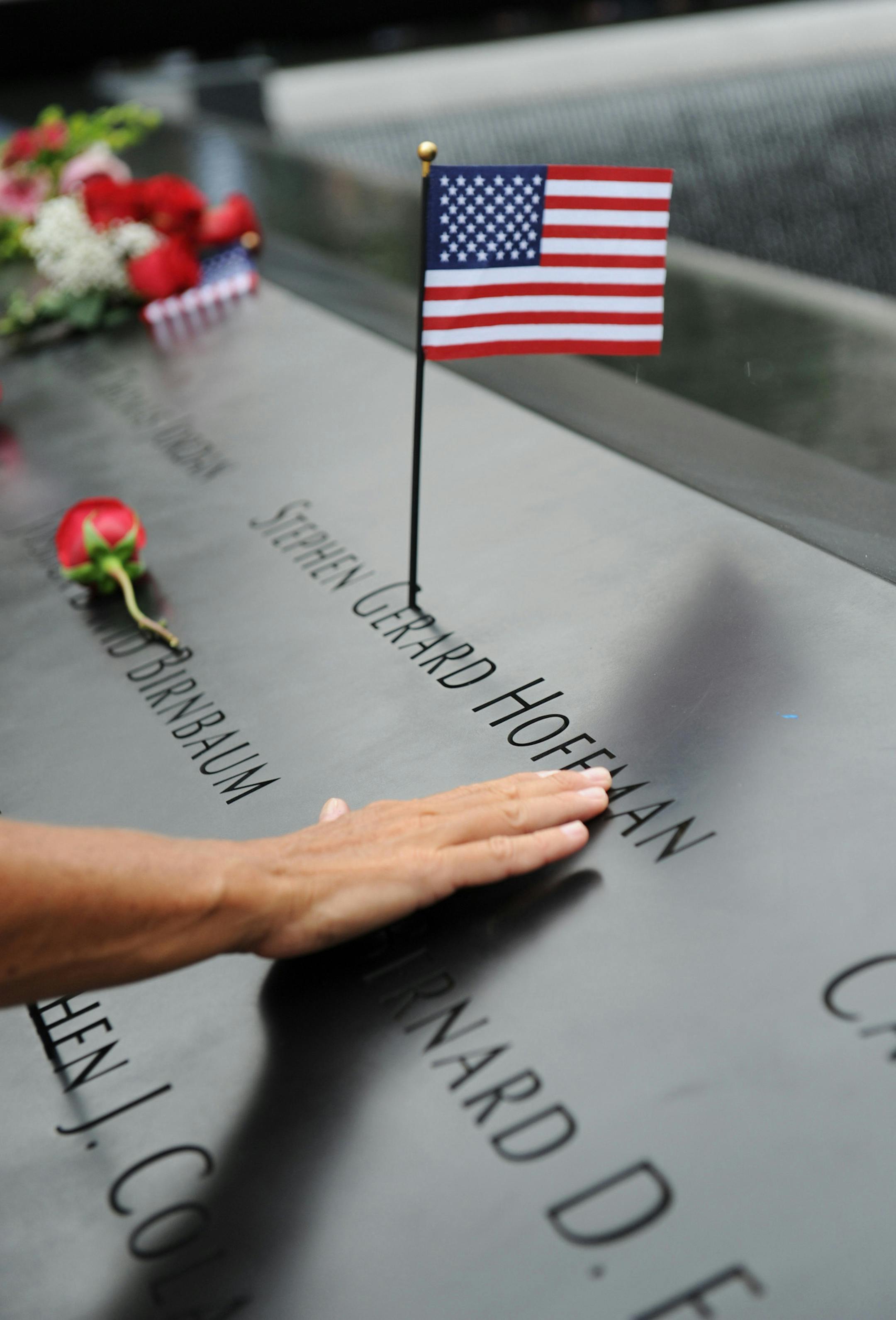 A mourner traces the name of a victim of the Sept. 11 terrorist attacks during a ceremony marking the 10th anniversary of the attacks Sunday, Sept. 11, 2011 at the National September 11 Memorial at the World Trade Center site in New York. (AP Photo/David Handschuh, Pool) ORG XMIT: MIN2013022819314379