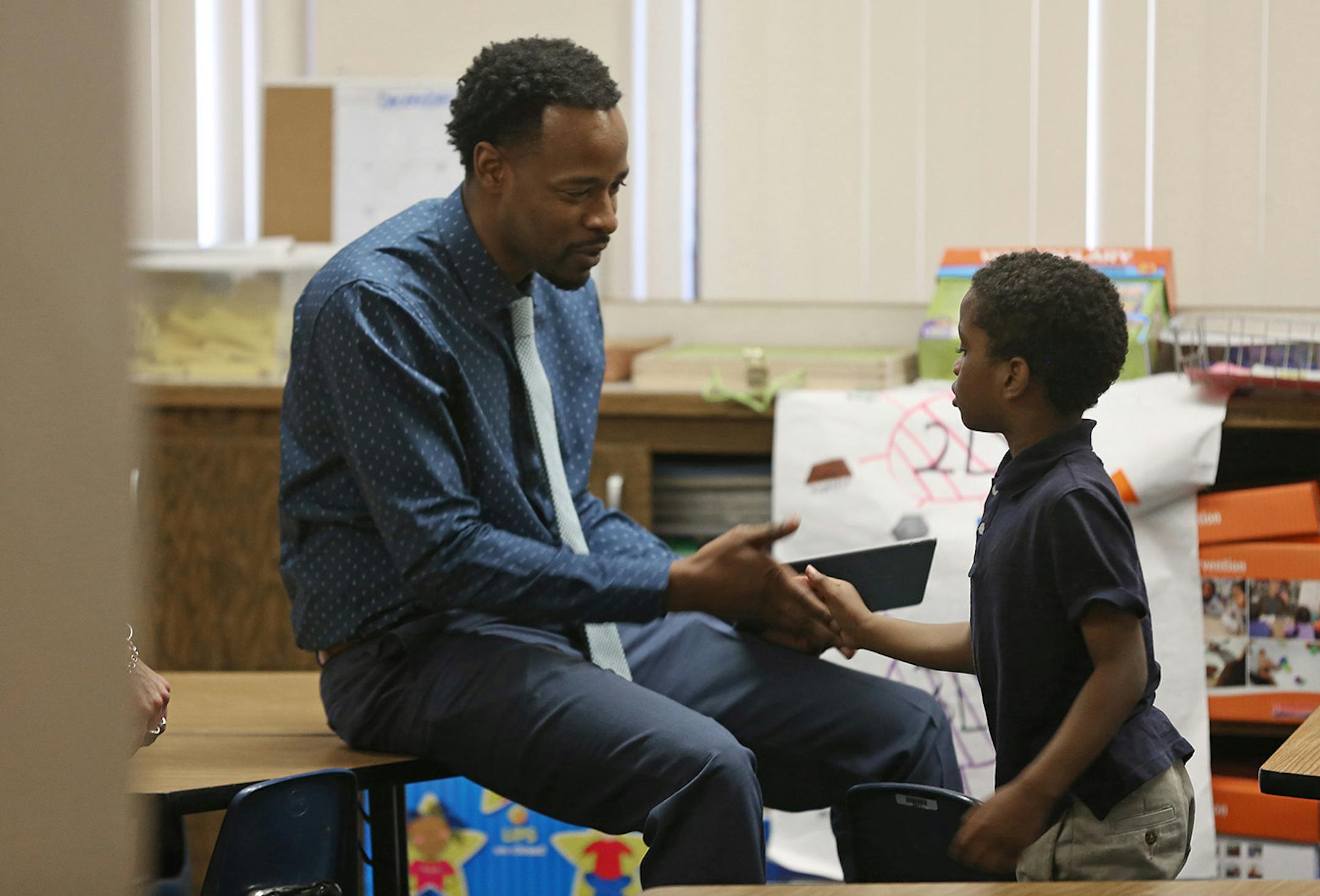 Language arts teacher Abdul Wright shook hands with kindergartner Christian Patterson at Best Academy on Monday after he won the 2016 Minnesota Teacher of the Year award.