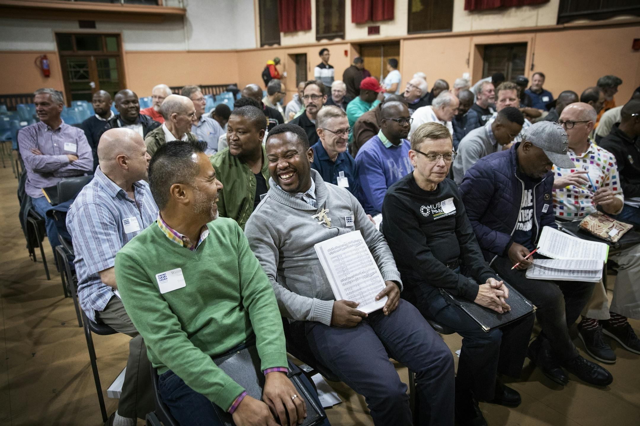 Singers in the tenor section chat before rehearsal. From left is Walter Tambor of the Minnesota Chorale and Xolani Mootane of the Gauteng Choristers.