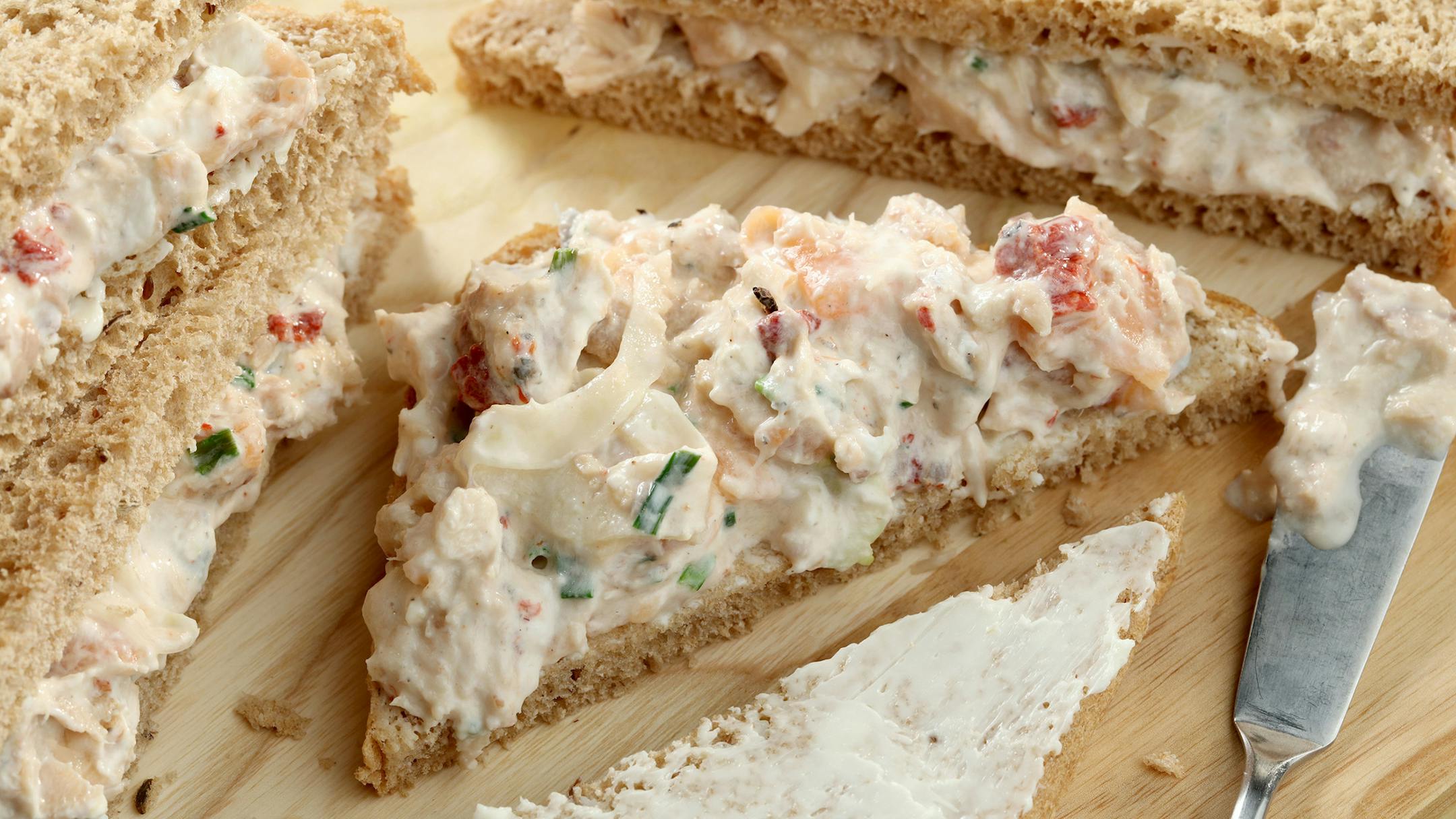 A salad of salmon, both smoked and canned, mixed with hot sauce, shopped fennel (for crunch), red pepper and chives, tops slices of rye in this smorrebrod-style sandwich.