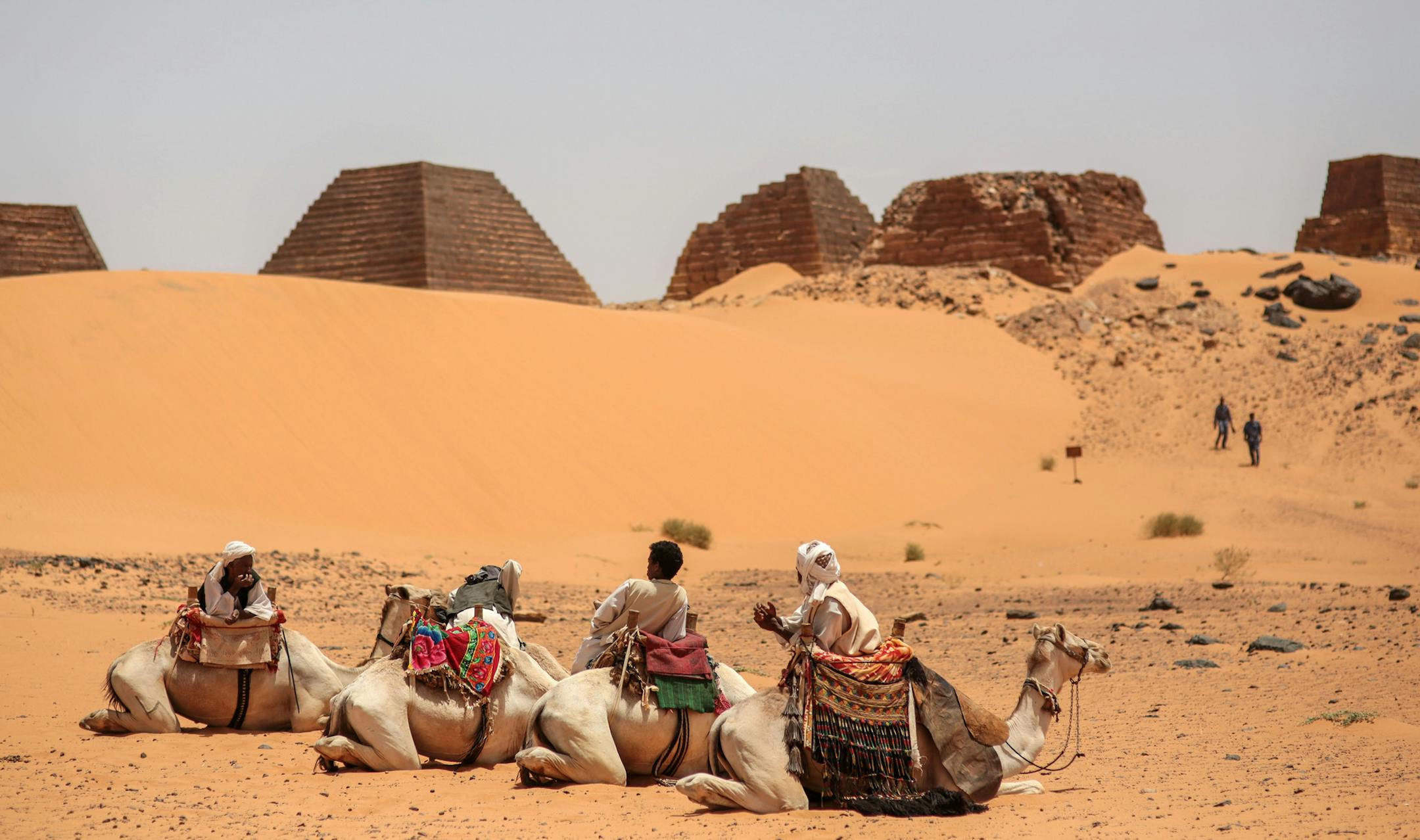 In this Thursday, April 16, 2015 photo, tour guides wait for tourists to offer them camel rides at the historic Meroe pyramids in al-Bagrawiya, 200 kilometers (125 miles) north of Khartoum, Sudan. The pyramids at Meroe are deserted despite being a UNESCO World Heritage site like those at Giza in Egypt. (AP Photo/Mosa'ab Elshamy)