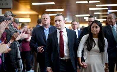 Ryan Londregan, a Minnesota state trooper, center, arrives before a court appearance at Hennepin County Government Center on Monday. Londregan is char