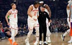 Knicks star Jalen Brunson (11) is helped off the court after suffering a knee injury in the first quarter Sunday at Cleveland.