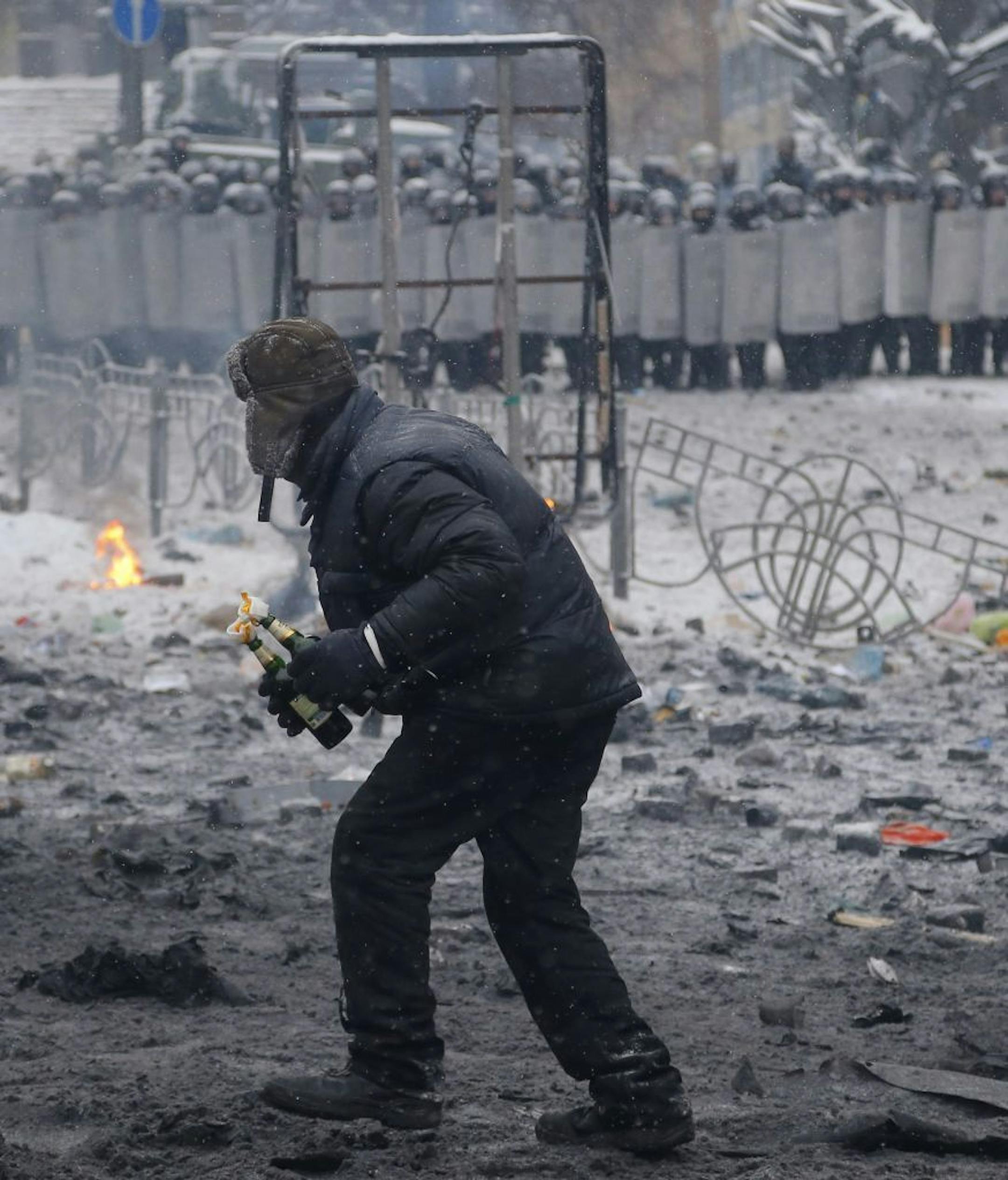 A protester prepares to throw a Molotov cocktail during clashes with police in central Kiev, Ukraine, early Wednesday, Jan. 22, 2014.