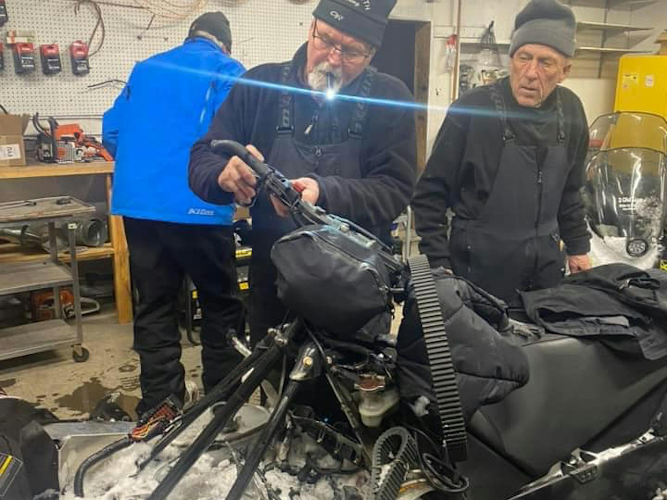 Paul Dick, 72, Rob Hallstrom, 65, and Rex Hibbert, 70 , repair one of their snowmobiles in Fort Yukon, Alaska.