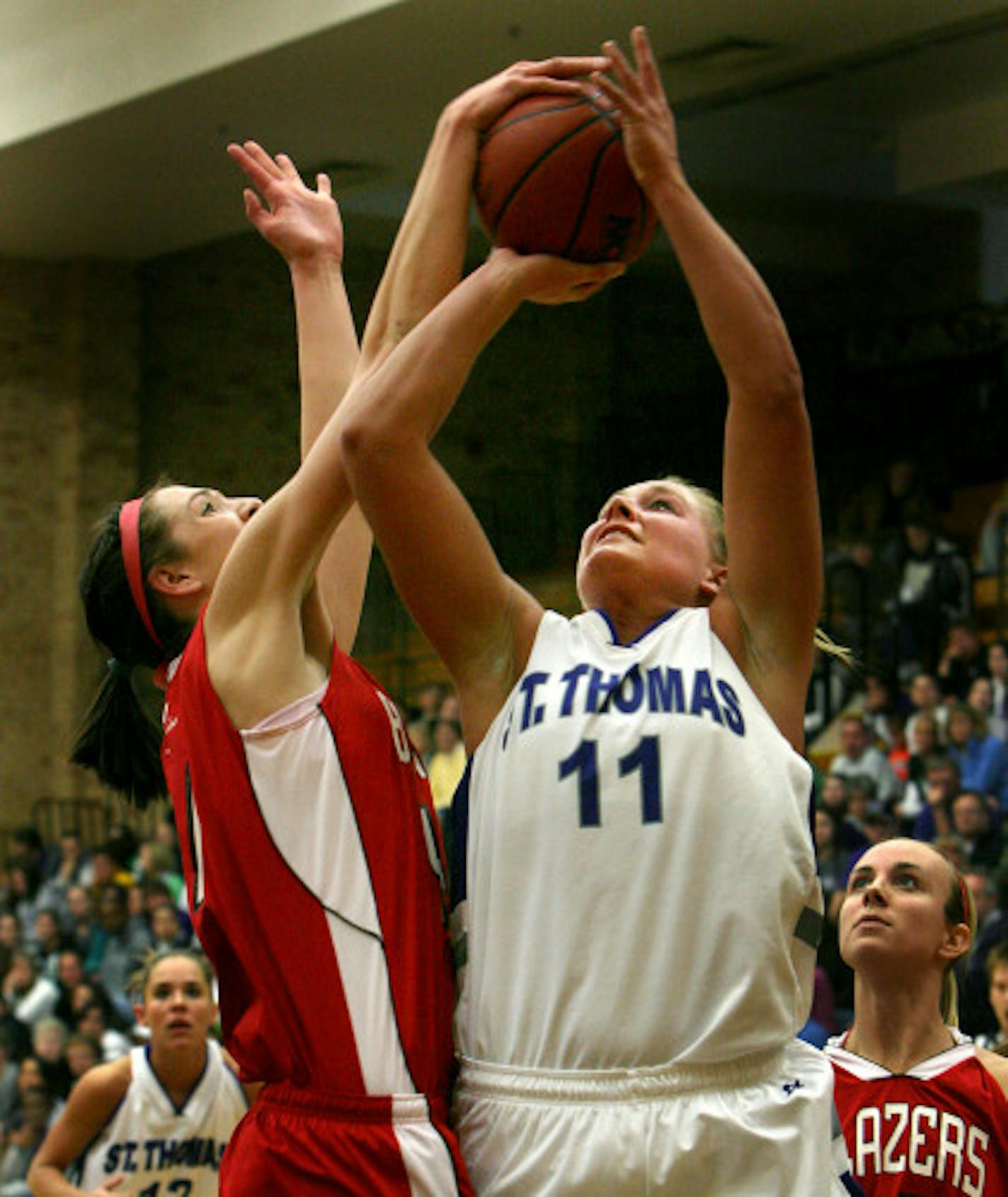 ELIZABETH FLORES � eflores@startribune.com February 23, 2008 - St. Paul, MN - St. Thomas' Carrie Embree goes up for two against heavy defense by St. Benedict's Danielle Frank during second half action at Schoenecker Arena at the University of St. Thomas. St. Thomas beat St. Benedict 56-55 in overtime action.