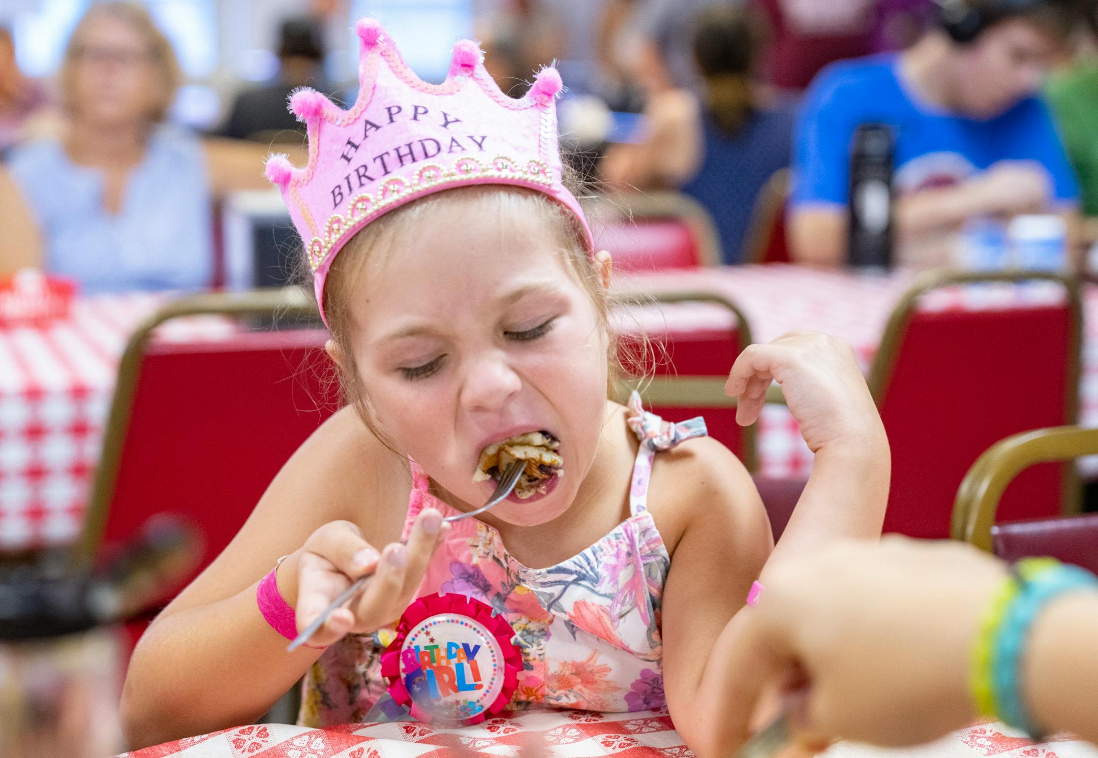 Olivia Kalas, 8, shovels pancakes in her mouth during her birthday breakfast at Hamline Church Dining Hall.