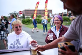 Lisa Olson, of Anoka, is served a glass of chardonnay Wednesday, Sept. 6, 2023 at Riverfront Memorial Park in Anoka, the first city to pilot a "social