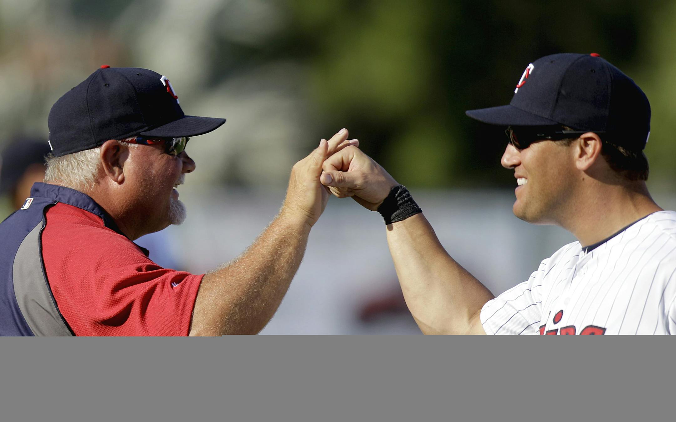 Minnesota Twins manager Ron Gardenhire, left, greets Sean Burroughs after the Twins defeated the Tampa Bay Rays 7-3 in a spring training baseball game Saturday, March 3, 2012, in Fort Myers, Fla. (AP Photo/David Goldman)