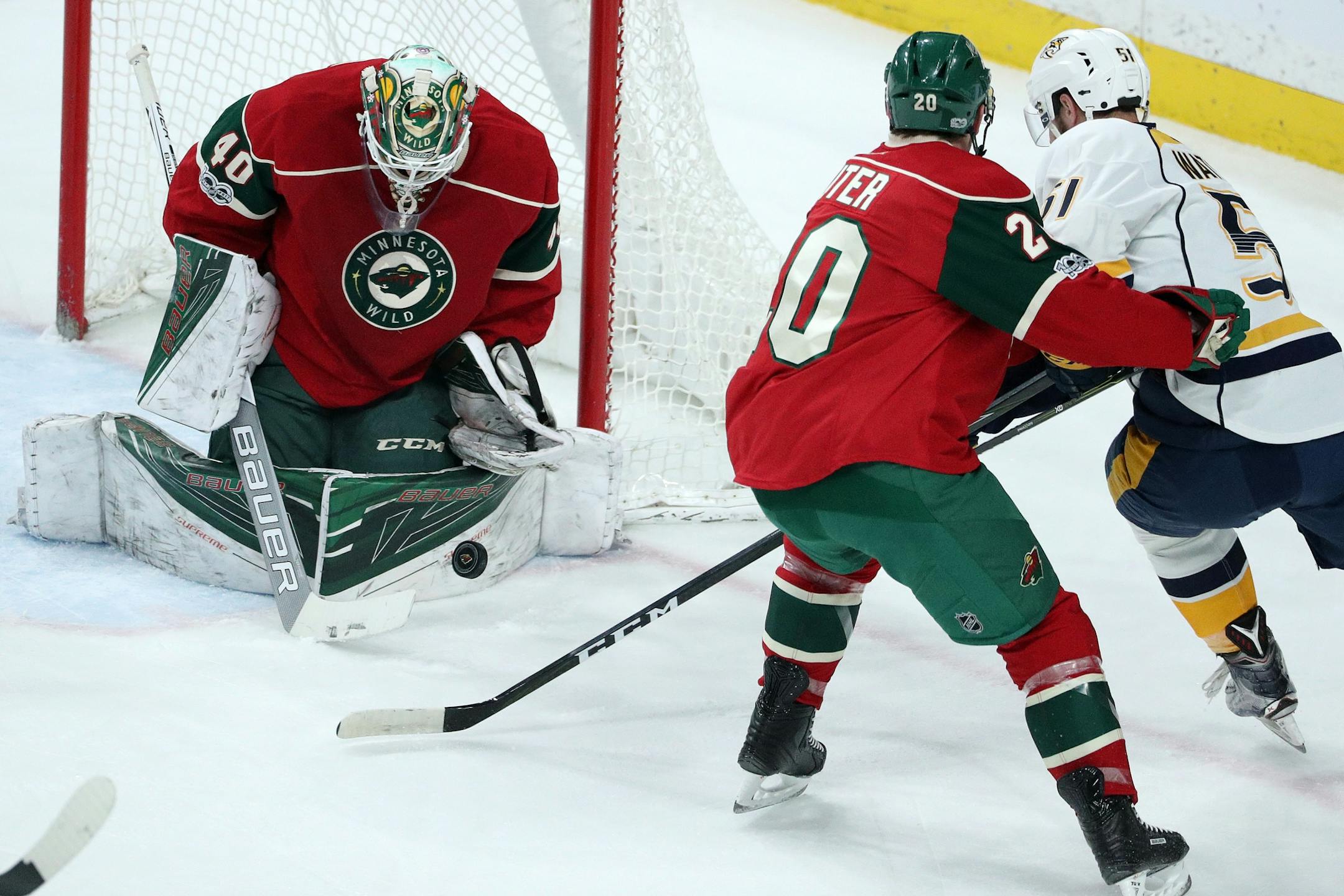 Minnesota Wild goalie Devan Dubnyk (40) stops a shot from Nashville Predators left wing Austin Watson (51) as Minnesota Wild defenseman Ryan Suter (20) defends during the first period.