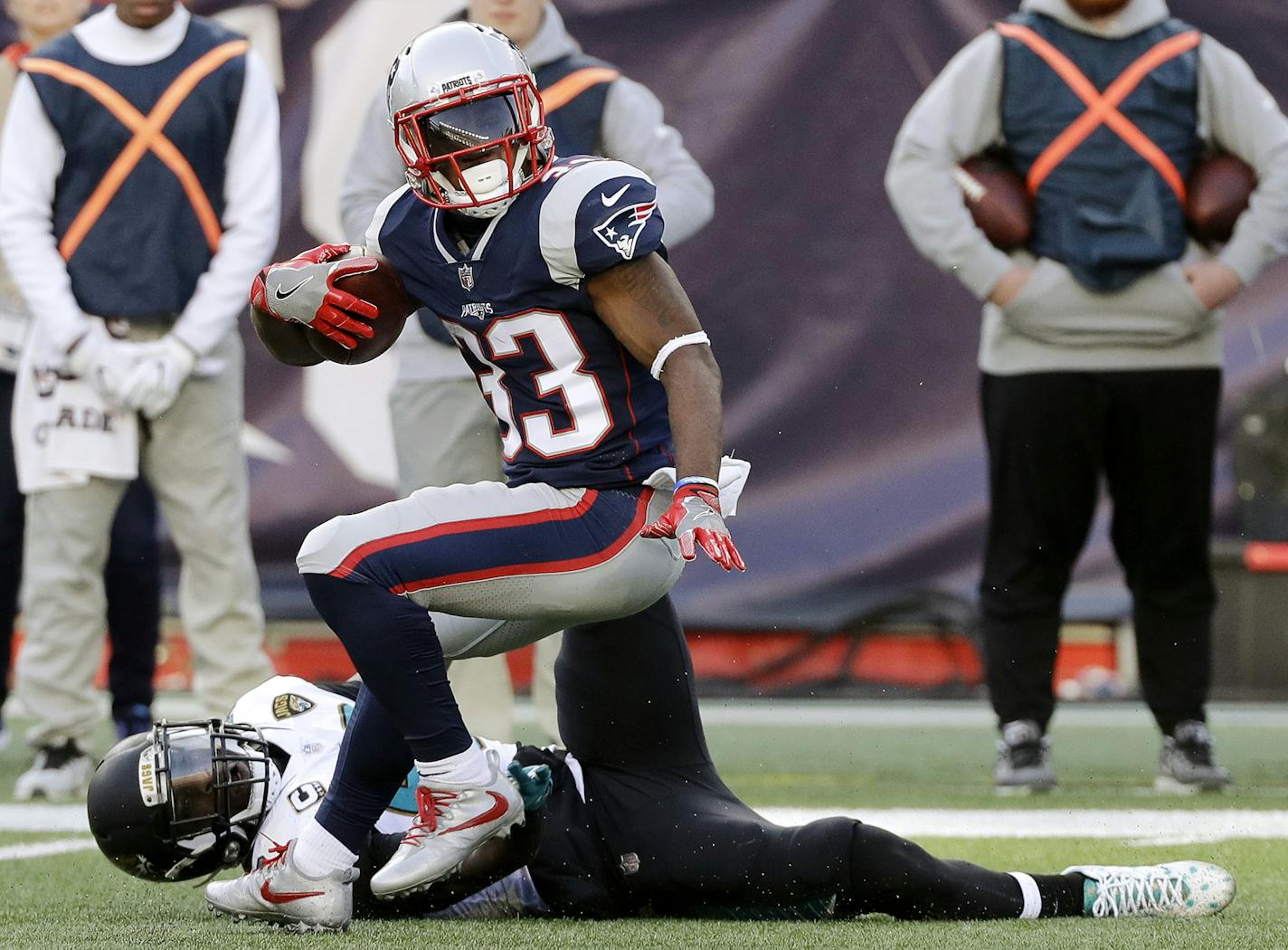 New England Patriots running back Dion Lewis (33) spins away from Jacksonville Jaguars linebacker Telvin Smith (50) during the first half of the AFC championship NFL football game, Sunday, Jan. 21, 2018, in Foxborough, Mass. (AP Photo/David J. Phillip) ORG XMIT: MIN2018013012520511