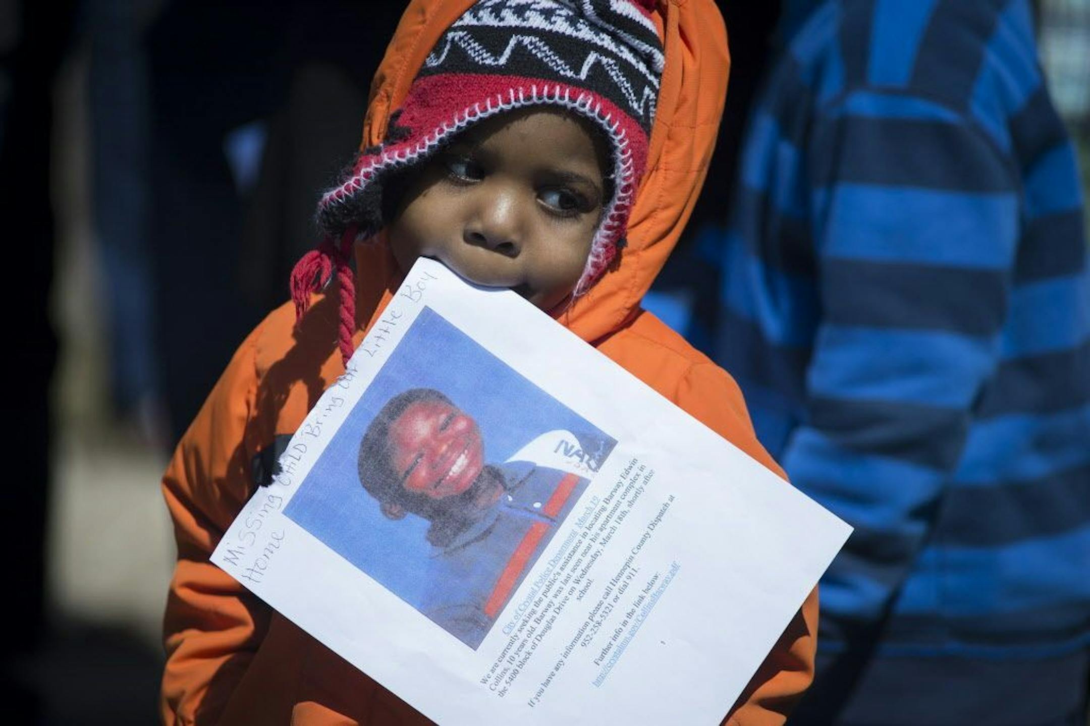 A young boy takes part in a community gathering marking the tenth day since the disappearance of 10-year-old Barway Collins, in Crystal, Minn. on Saturday, March 28, 2015.