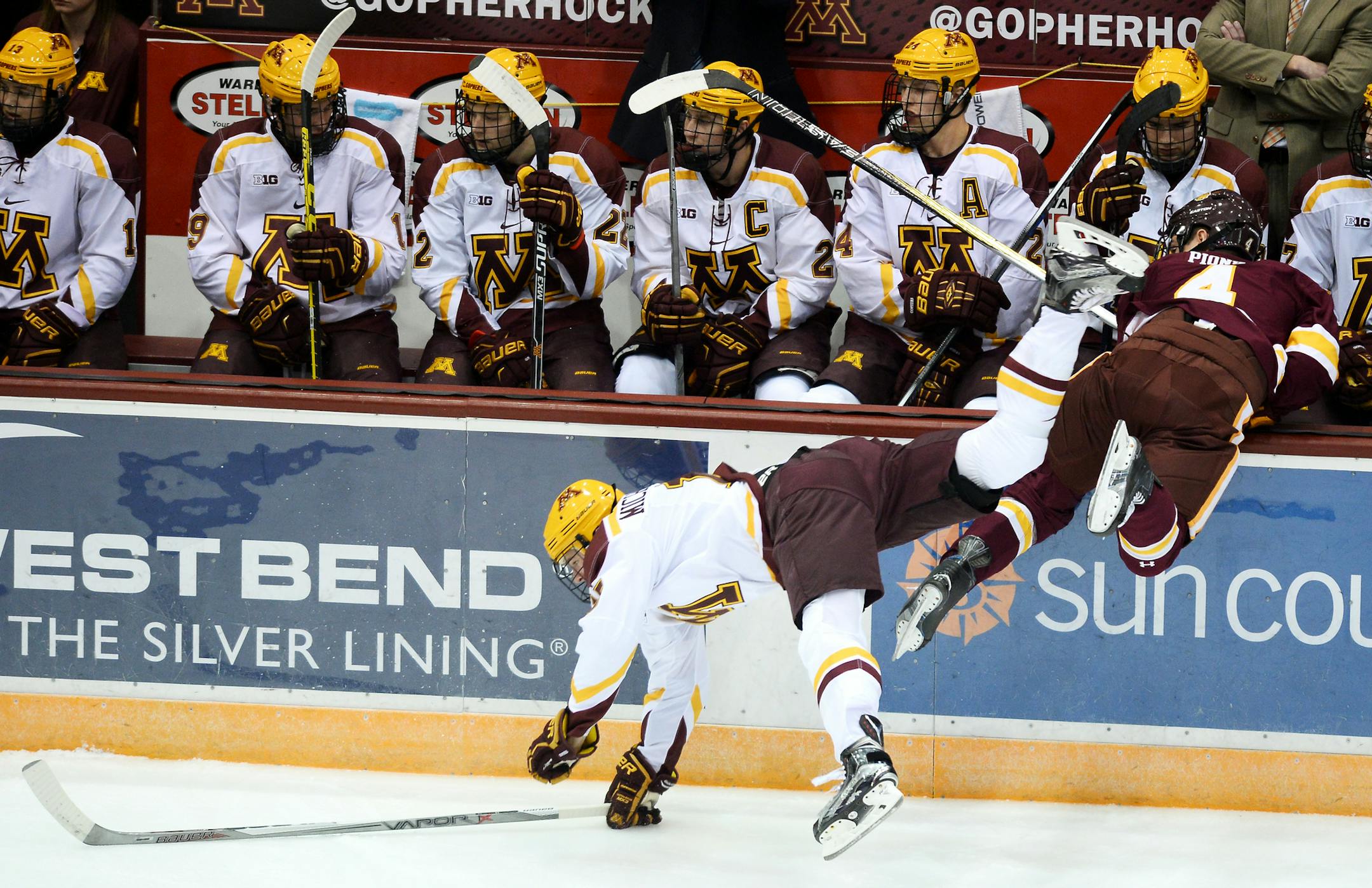 University of Minnesota Duluth defenseman Neal Pionk (4) fell into the Gophers' bench after checking University of Minnesota left wing A.J. Michaelson (15) early in the first period. ] (AARON LAVINSKY/STAR TRIBUNE) aaron.lavinsky@startribune.com The Minnesota Gophers Men's Hockey Team plays the University of Minnesota Duluth Bulldogs on Friday, Oct. 16, 2015 at Mariucci Arena in Minneapolis, Minn.