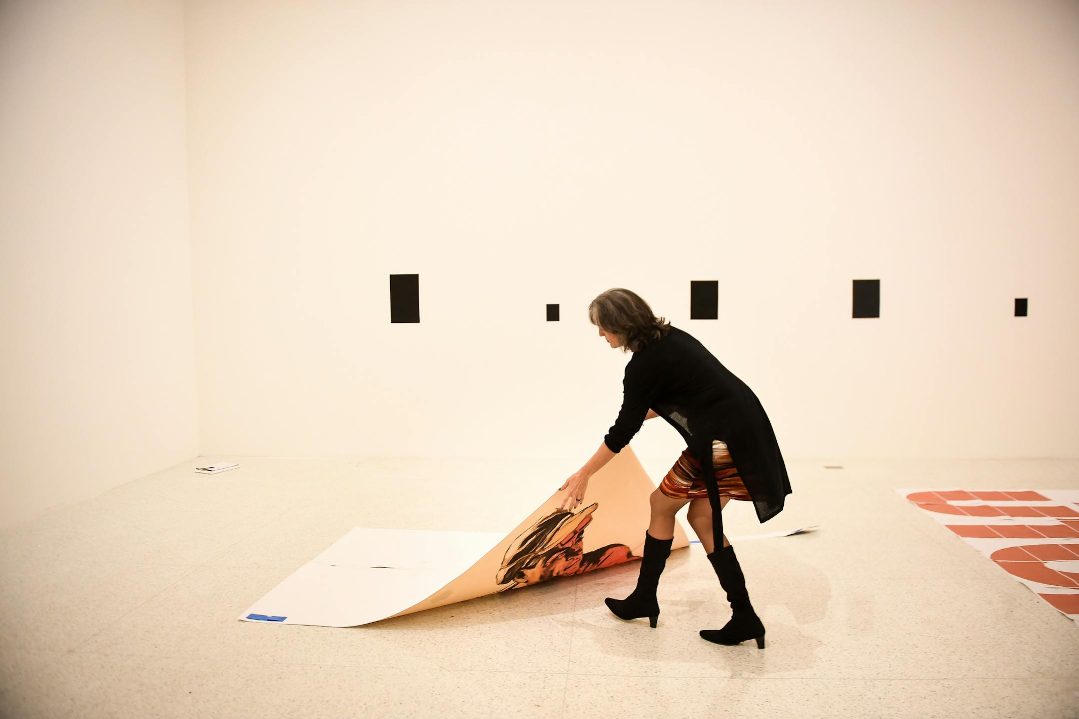 Walker Art Center Executive Director Olga Viso lifted a printed placeholder of "Productivism," a painting by Eduardo Ponjuan and Rene Francisco, during installation of the "Adios Utopia" exhibition at the Walker Oct. 27, 2017.
