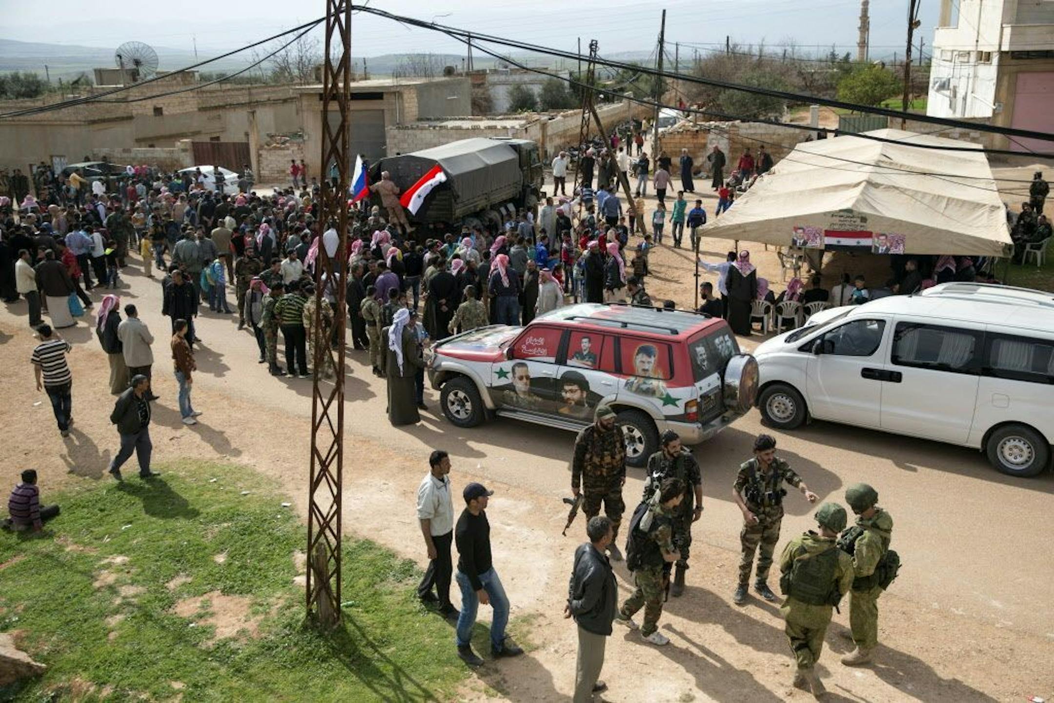 People gather around a Russian military truck to receive a food aid in Maarzaf, about 15 kilometers west of Hama, Syria, Wednesday, March 2, 2016.