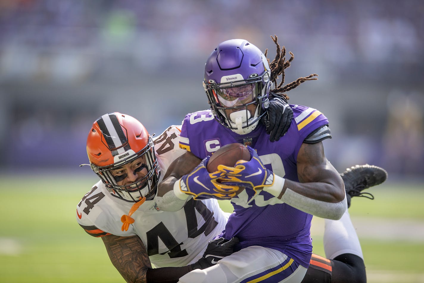 Vikings running back Dalvin Cook ran for a first down despite defensive pressure from Browns linebacker Sione Takitaki in the first quarter