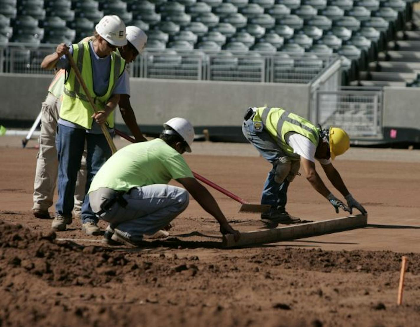 Grounds crew workers level dirt on what will be the infield for the new Minnesota Twins Target Field Stadium. Things are beginning to shape up on the field, with the field heating system and drainage system are in place and dirt is being leveled with the sod expected to come soon.