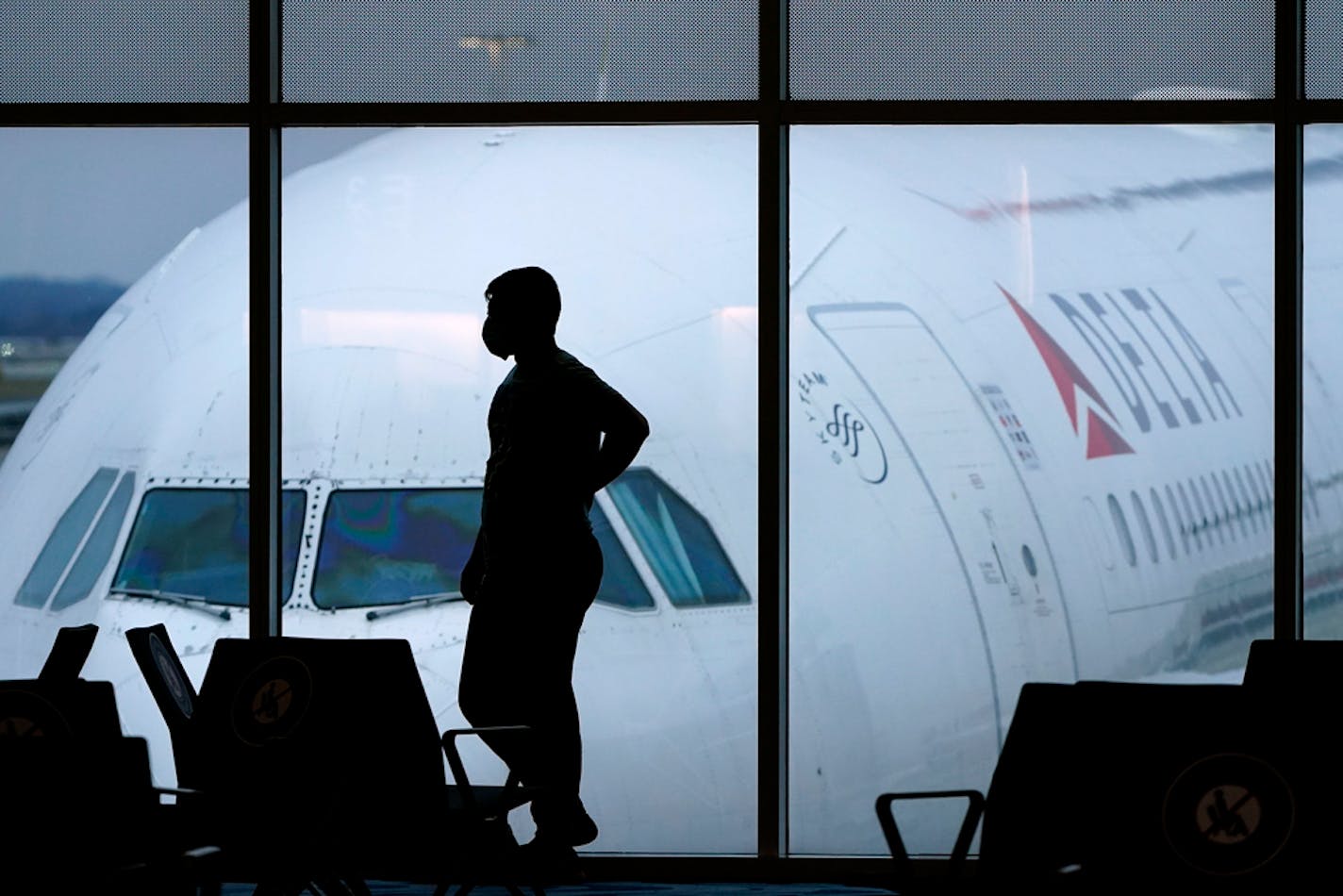 FILE - In this Feb. 18, 2021 file photo, a passenger wears a face mask to help prevent the spread of the new coronavirus as he waits for a Delta Airlines flight at Hartsfield-Jackson International Airport in Atlanta. Airlines have reported about 3,000 cases of disruptive passengers since Jan. 1, according to a spokesman for the Federal Aviation Administration. It has gotten so bad that the airlines, flight attendants and pilots sent a letter to the U.S. Justice Department on Monday, June 21, urging "that more be done to deter egregious behavior." (AP Photo/Charlie Riedel)