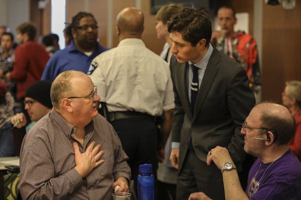 Mayor Jacob Frey chatted with Timothy J. Korsmoe (left) at the beginning of a community meeting about public safety on March 28, 2018 at the Davis Cen