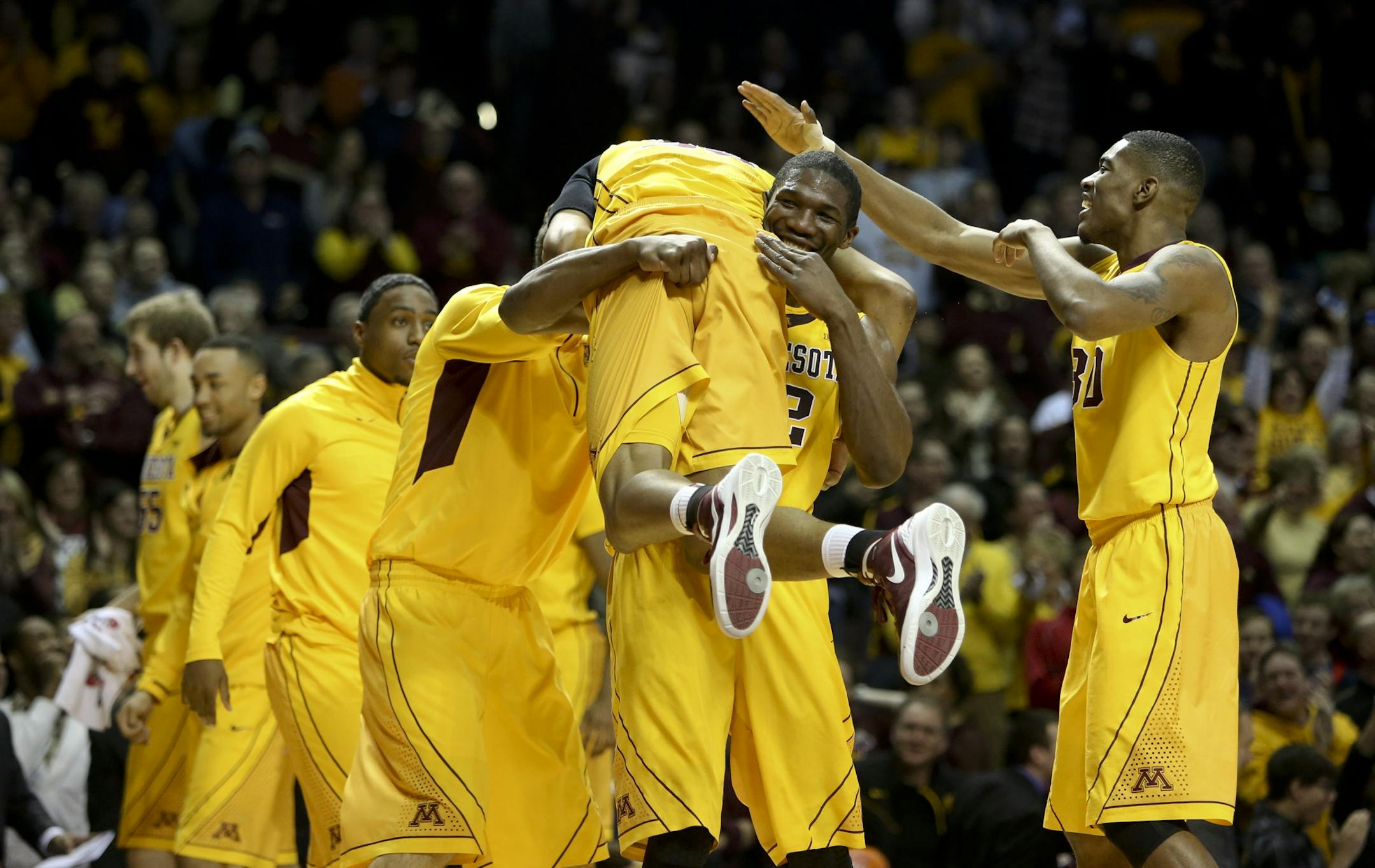 Gopher's Trevor Mbakwe picked up teammate Rodney Williams Jr. during a timeout after making a hand-switching dunk during the first half at Williams Arena in Minneapolis, Min., Saturday, March 2, 2013.