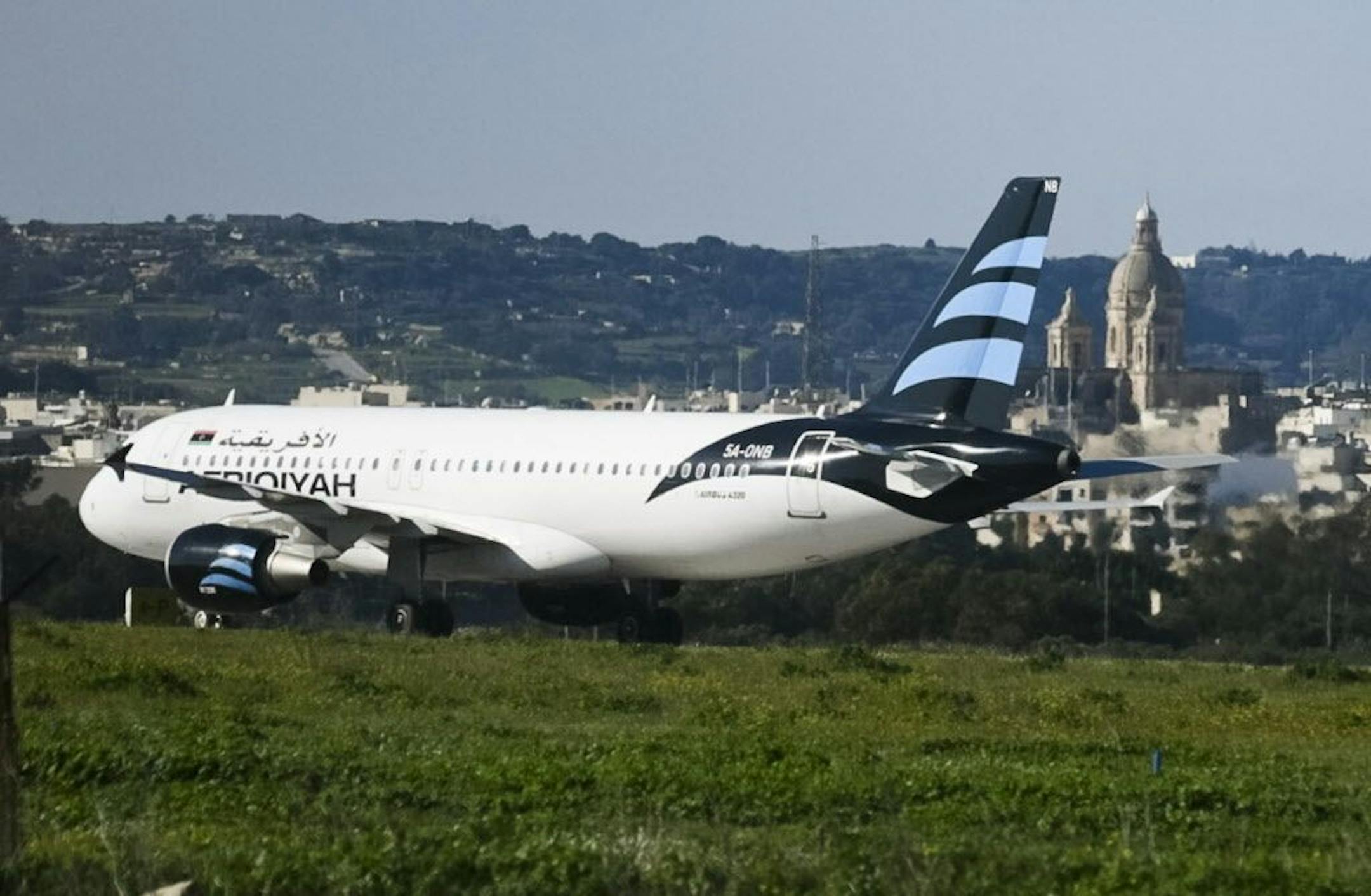 An Afriqiyah Airways plane from Libya stands on the tarmac at Malta's Luqa International airport, Friday, Dec. 23, 2016. Malta's state television says two hijackers who diverted a Libyan commercial plane to the Mediterranean island nation have threatened to blow it up.