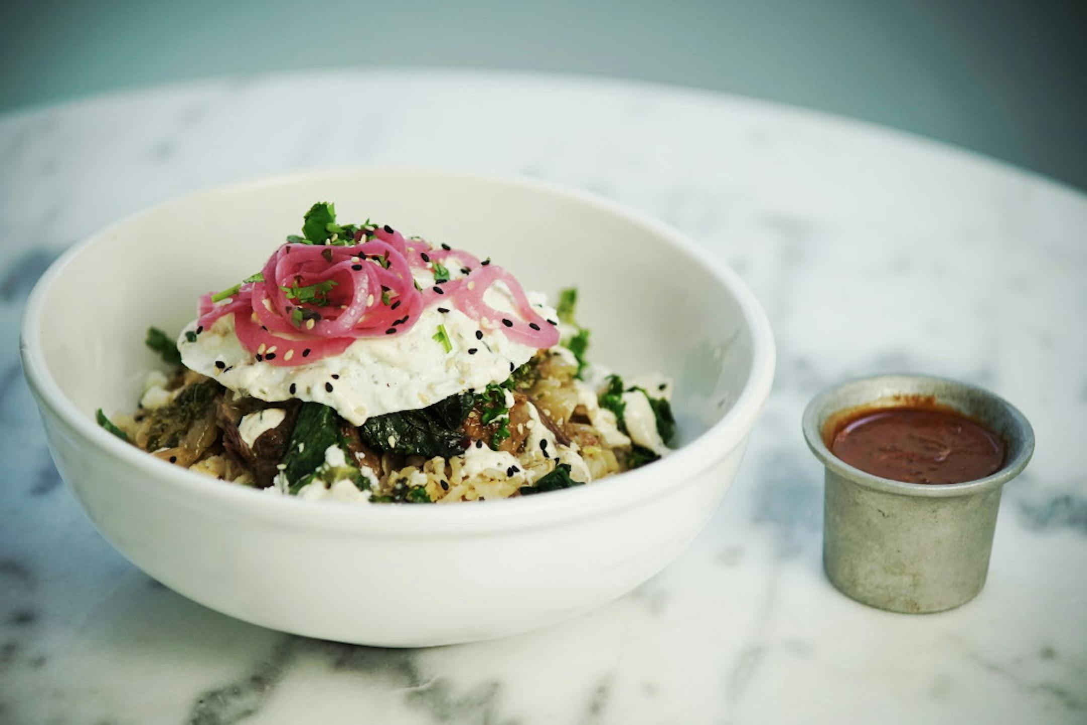 Bottle Rocket’s brown rice bowl:  seared beef, pickled red onion, fried egg, power greens, cilantro cream.