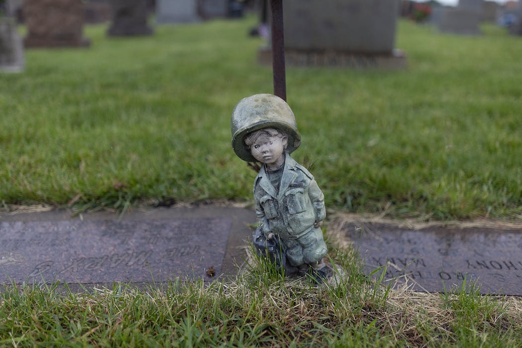 A statue sits near a gravesite at the Church of the Assumption cemetery in Richfield during a Memorial Day ceremony on Monday.